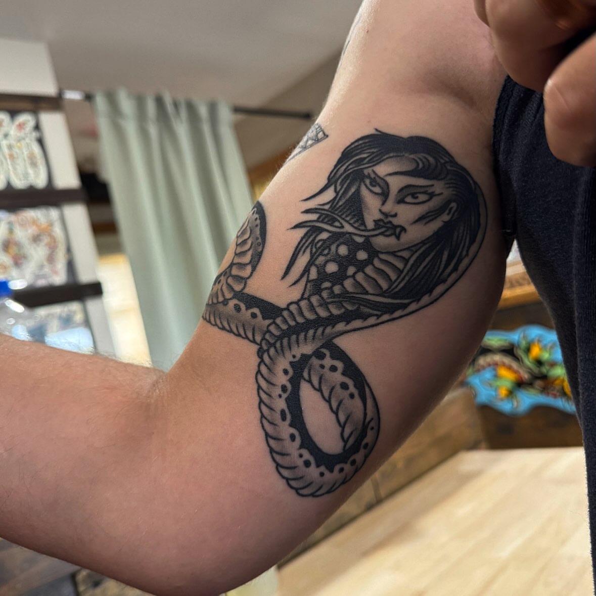 Snake and woman black and grey tattoo on the forearm by Larry Love