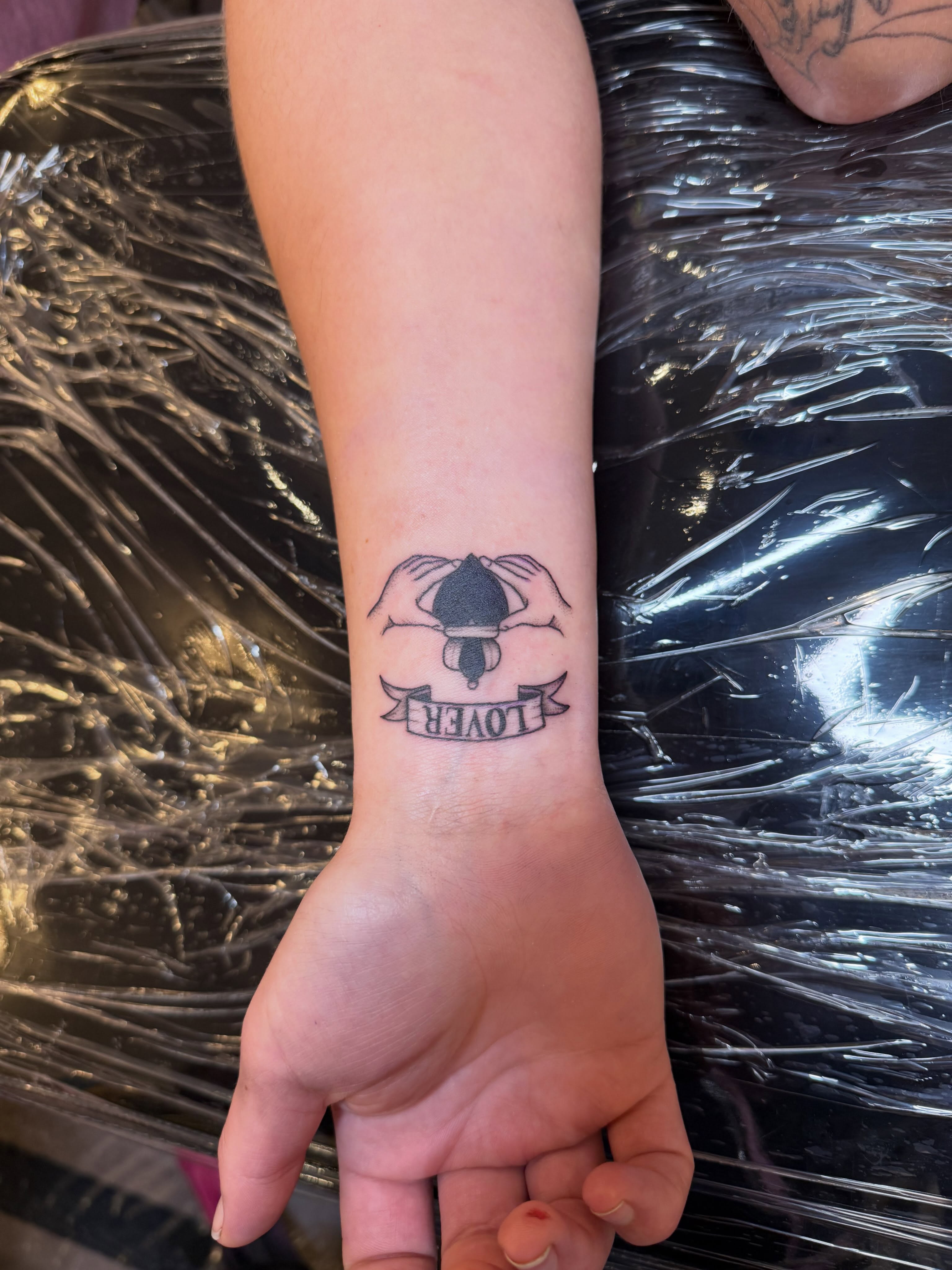 Hands covering a lantern black and grey tattoo on the forearm by Jennylee Aerts, Asbury Park, New Jersey