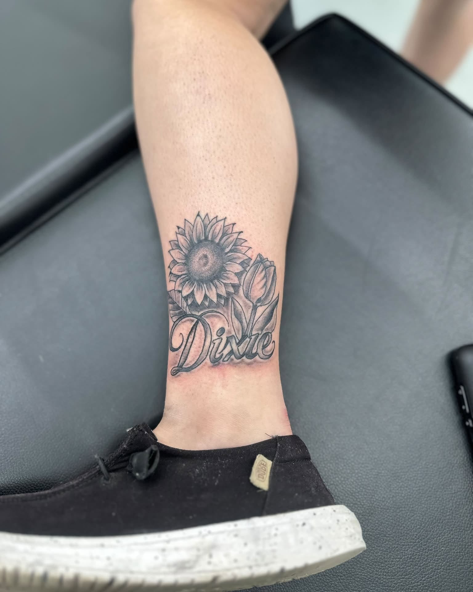 Sunflower and script black and grey tattoo on the forearm by Brian Lambert