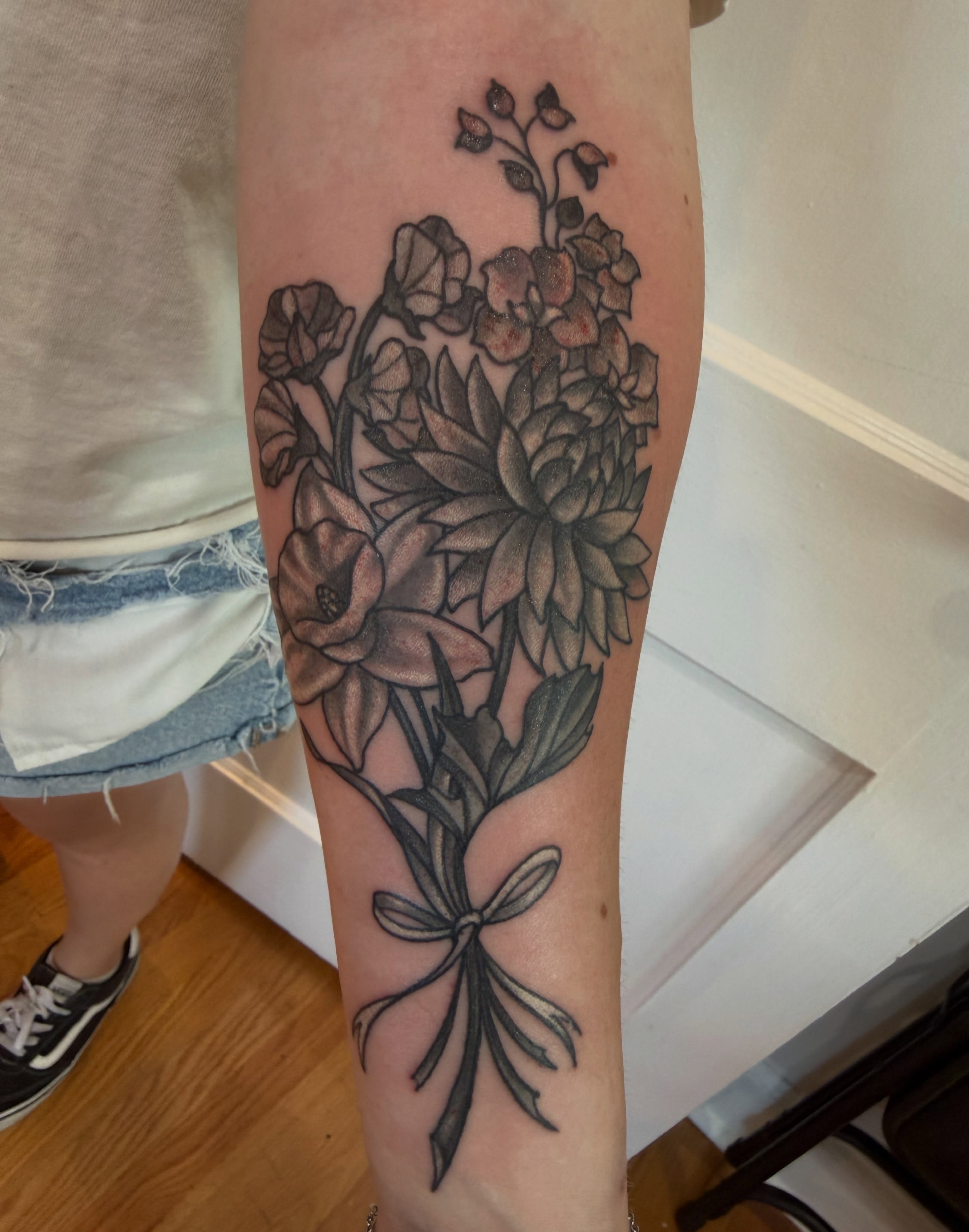 Flower bouquet black and grey tattoo on the forearm by Laura Saadati Kepper