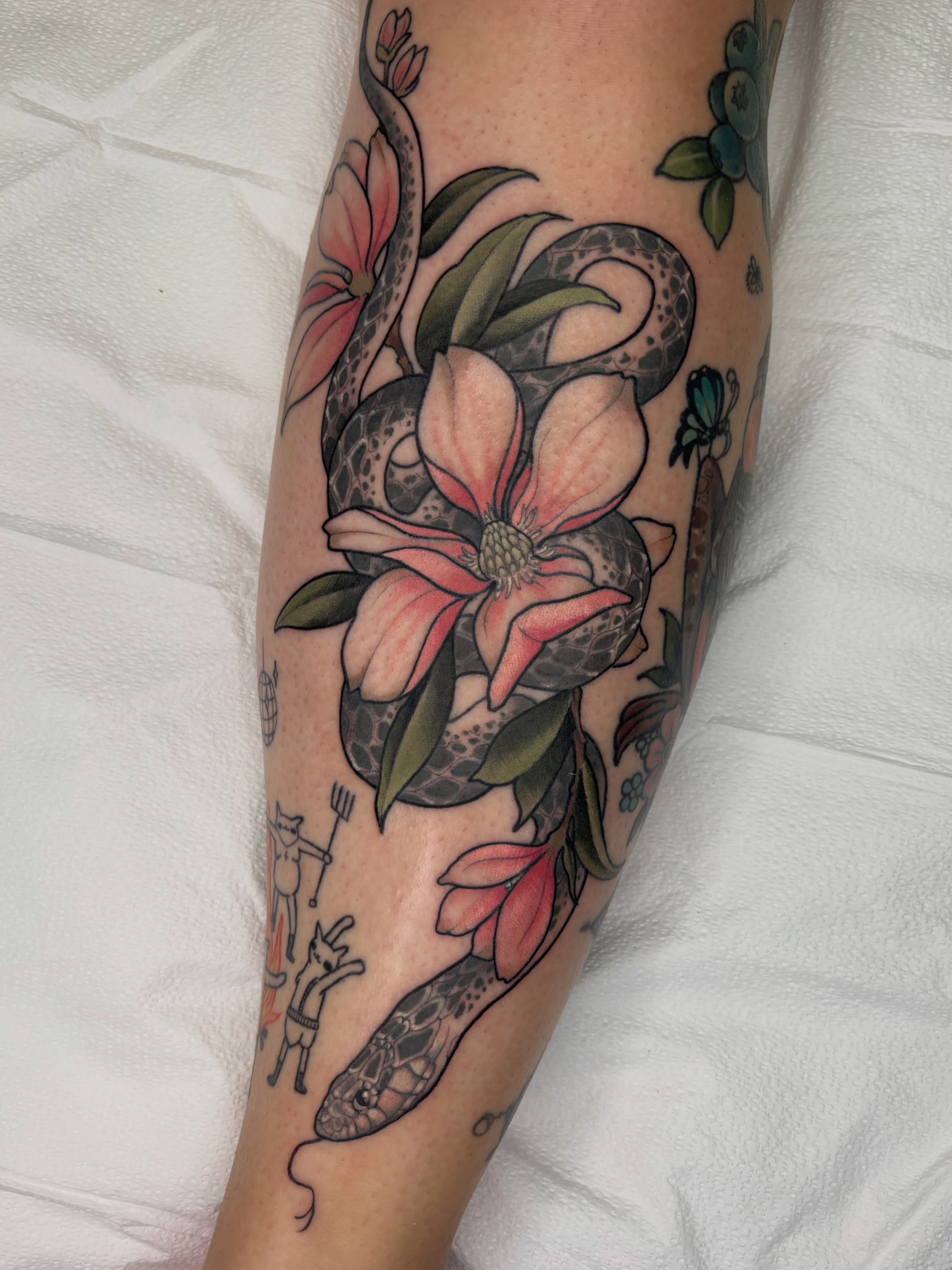 Snake and magnolia American traditional tattoo on the forearm by Samantha Compasso Ford