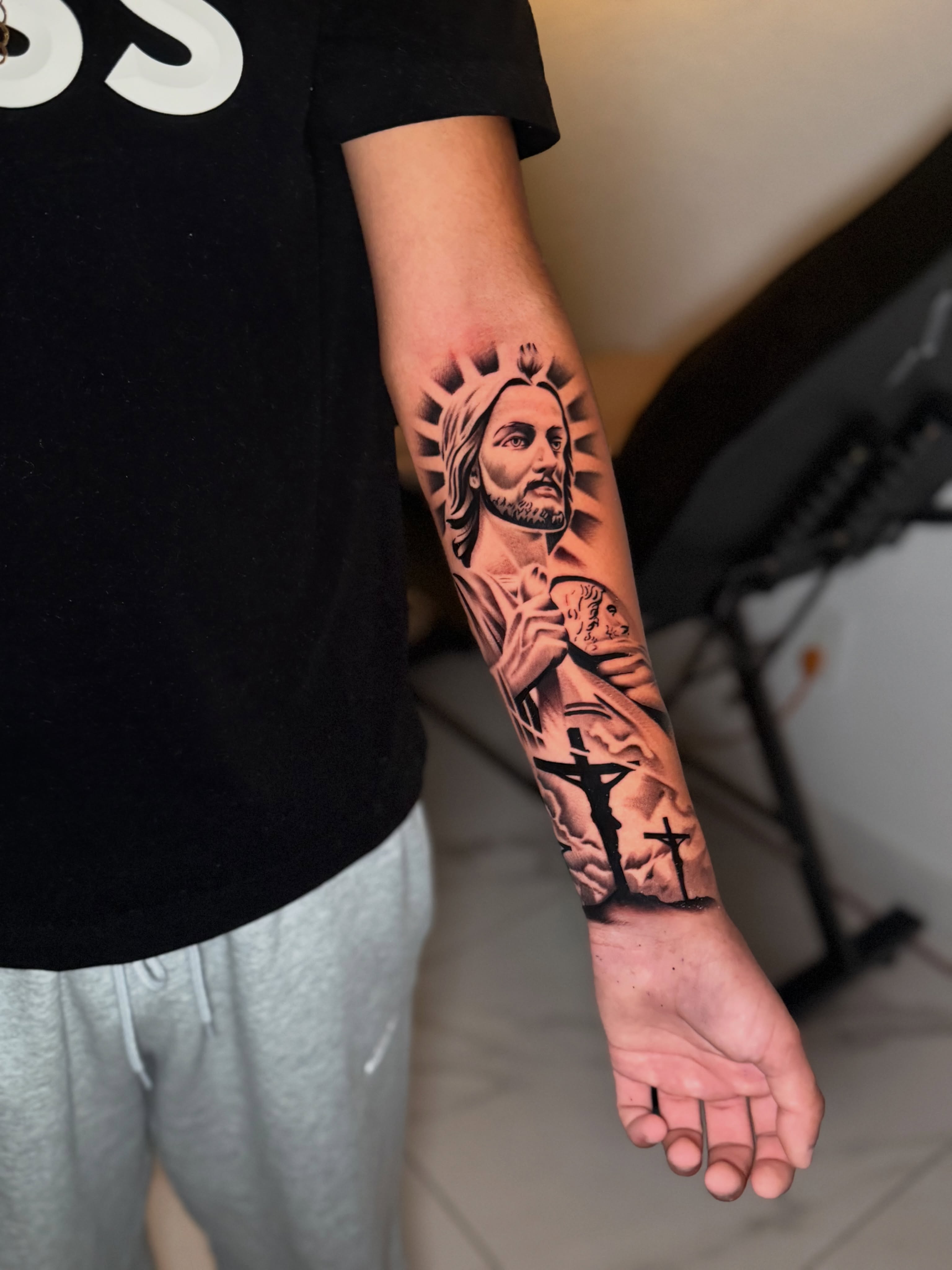 Religious figure black and grey tattoo on the forearm by InkbyCasillas