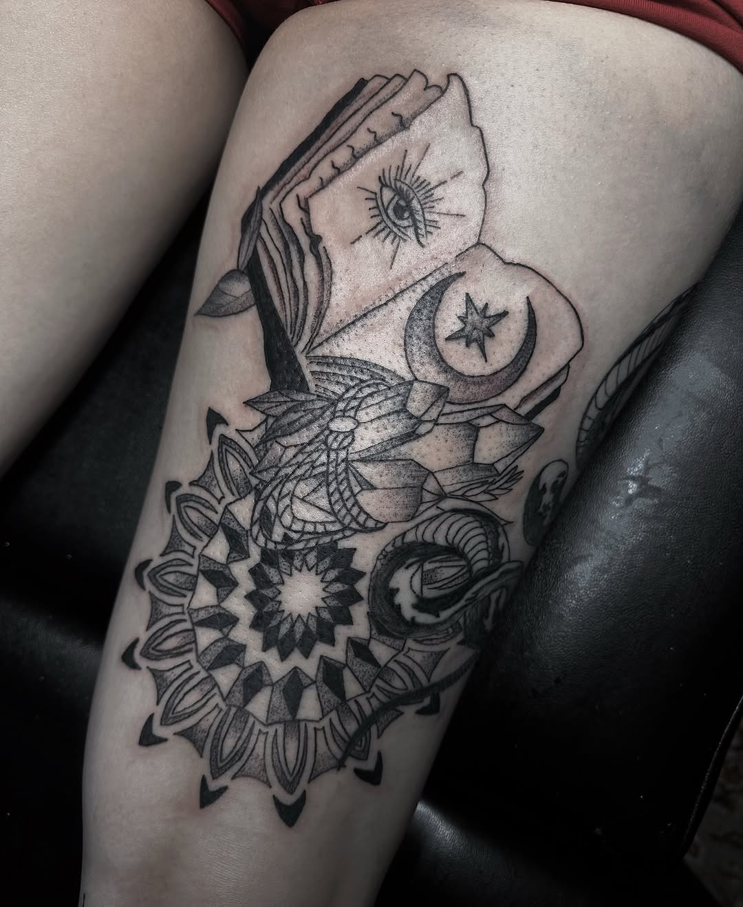 Book and celestial symbols geometric tattoo on the thigh by Marly Quinn