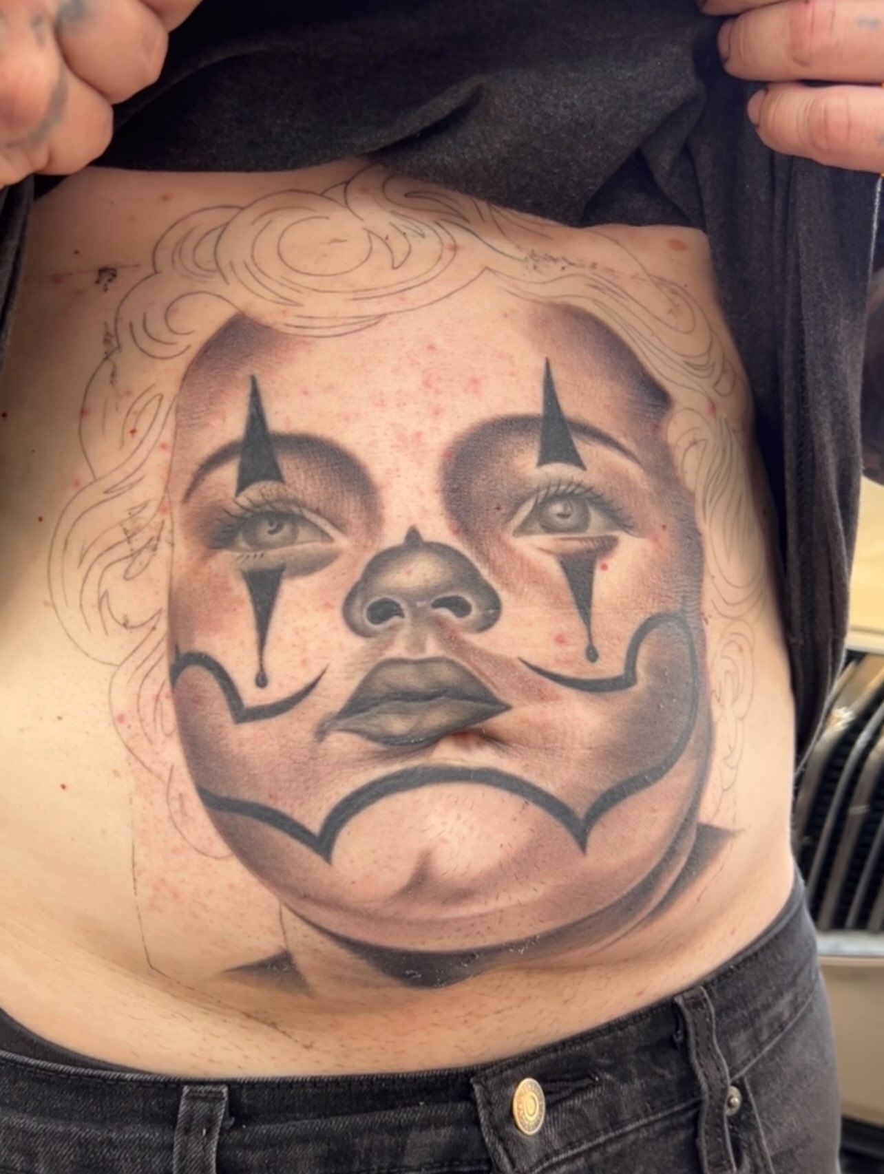 Clown face black and grey tattoo on the torso by Dallas tx tattoo artist ✝️