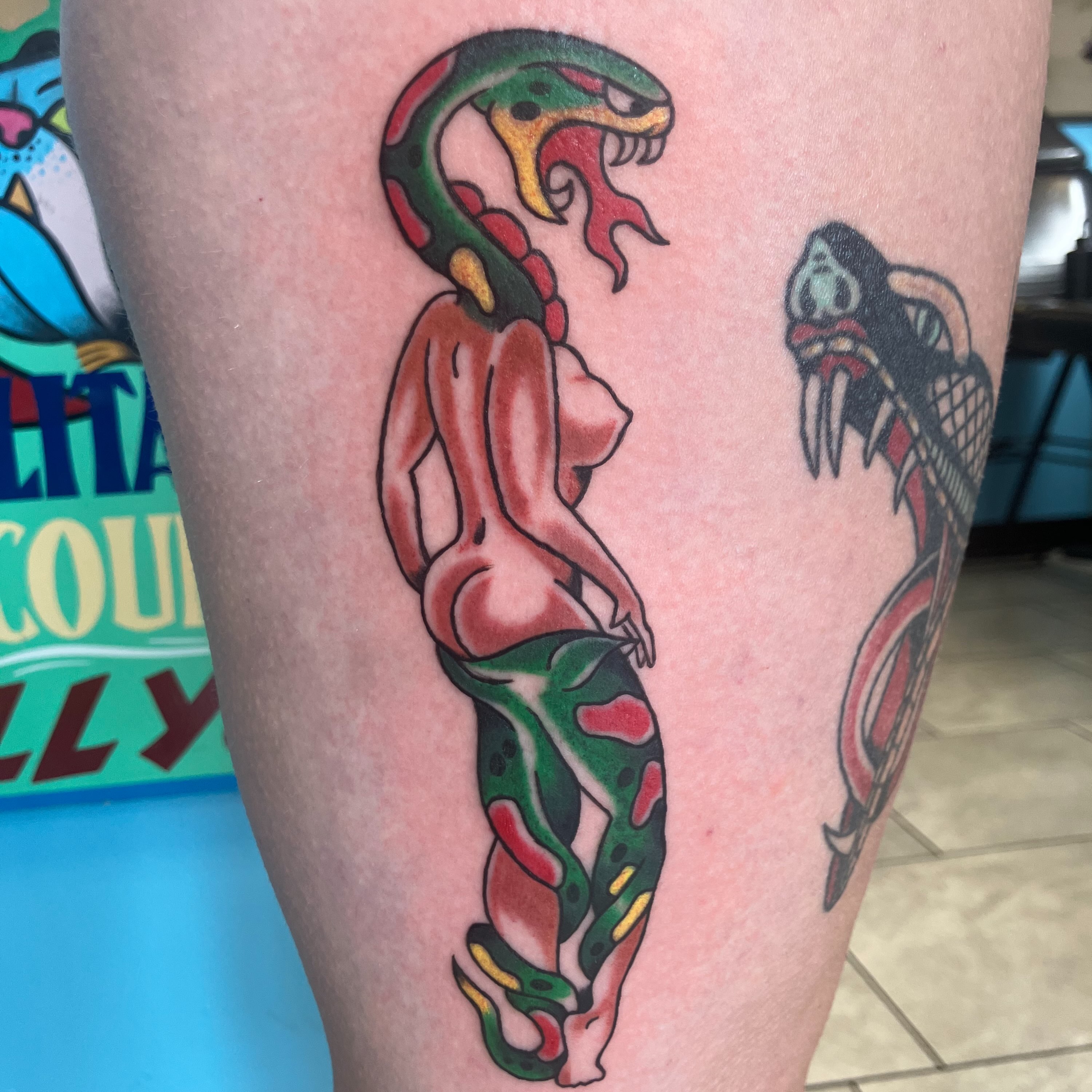 Snake and woman American traditional tattoo on the thigh by Bryant Johnson
