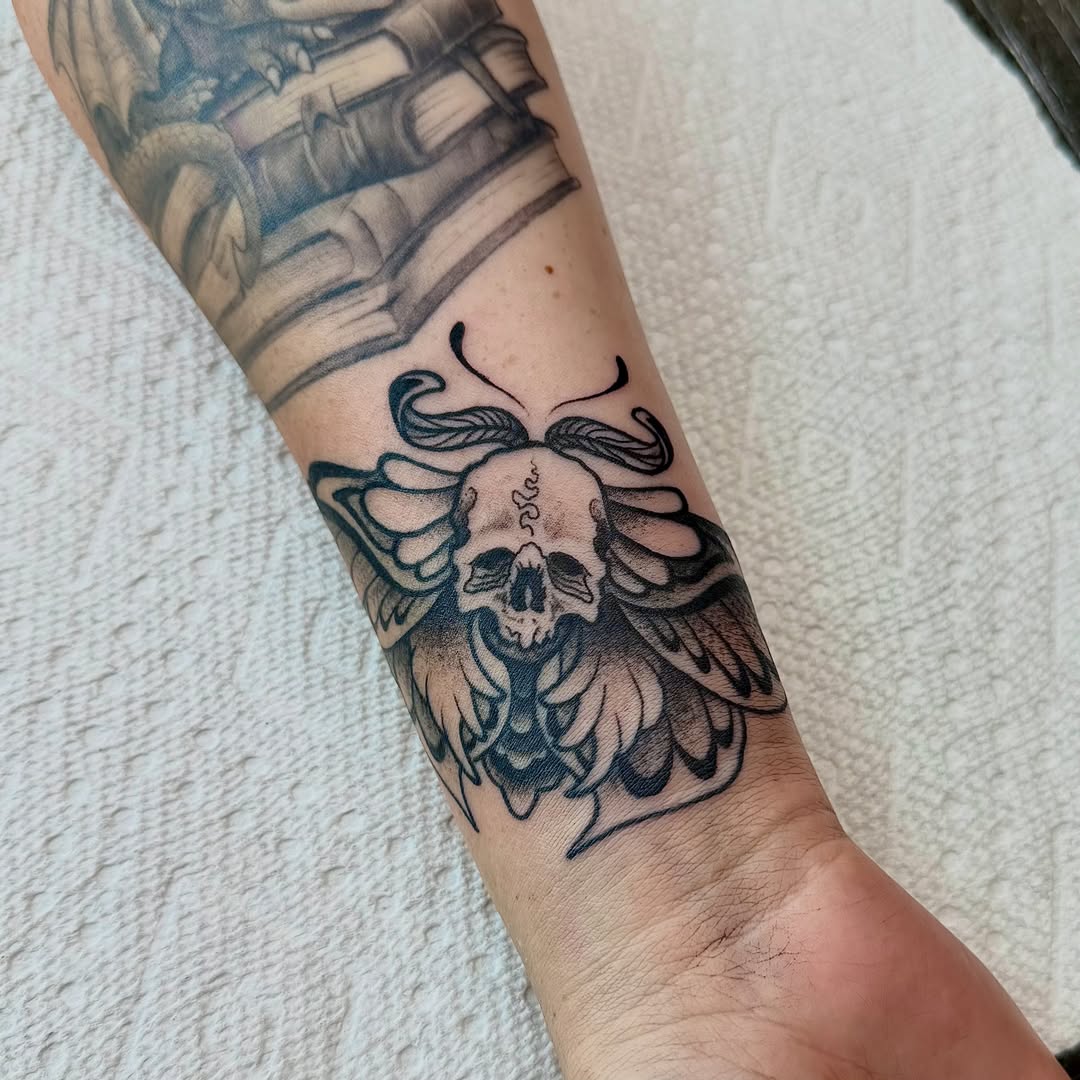 Skull with wings black and grey tattoo on the forearm by Jamie Hall, Kansas City, Missouri