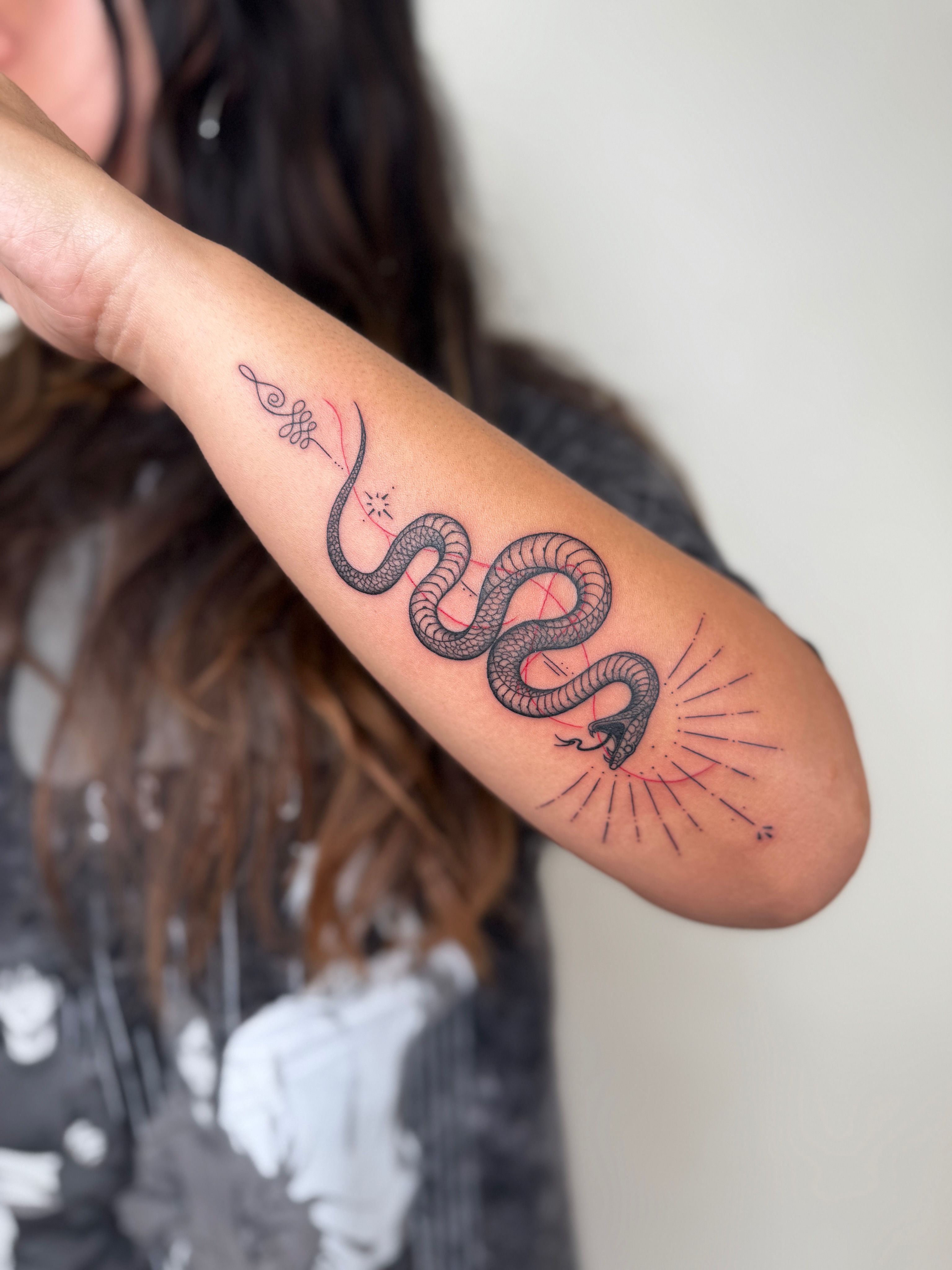 Snake black and grey tattoo on the forearm by Jadyn Pang