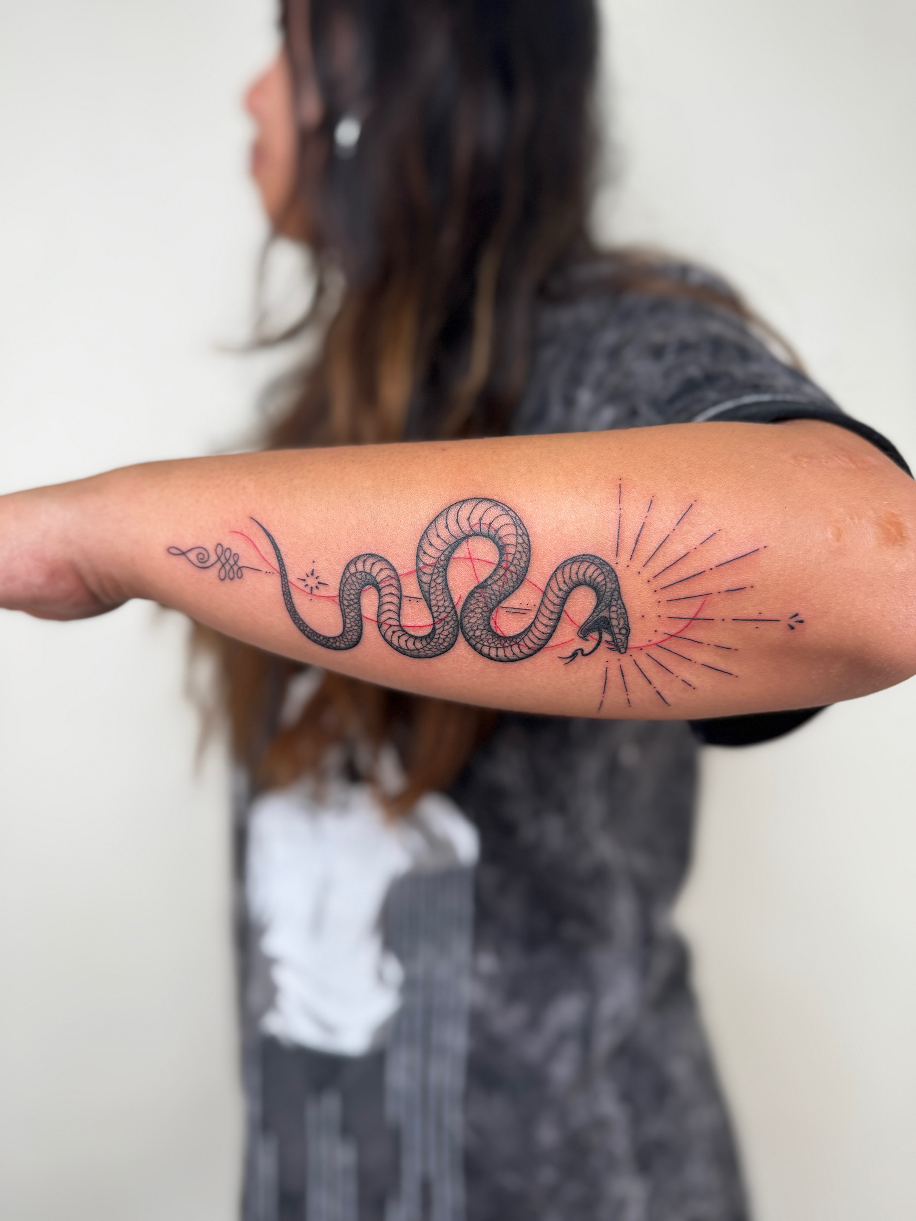 Snake black and grey tattoo on the forearm by Jadyn Pang