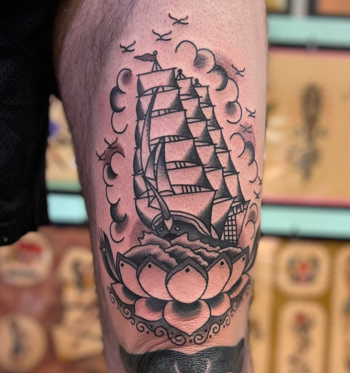 Sailboat and lotus American traditional tattoo on the calf by Mikey Montoya