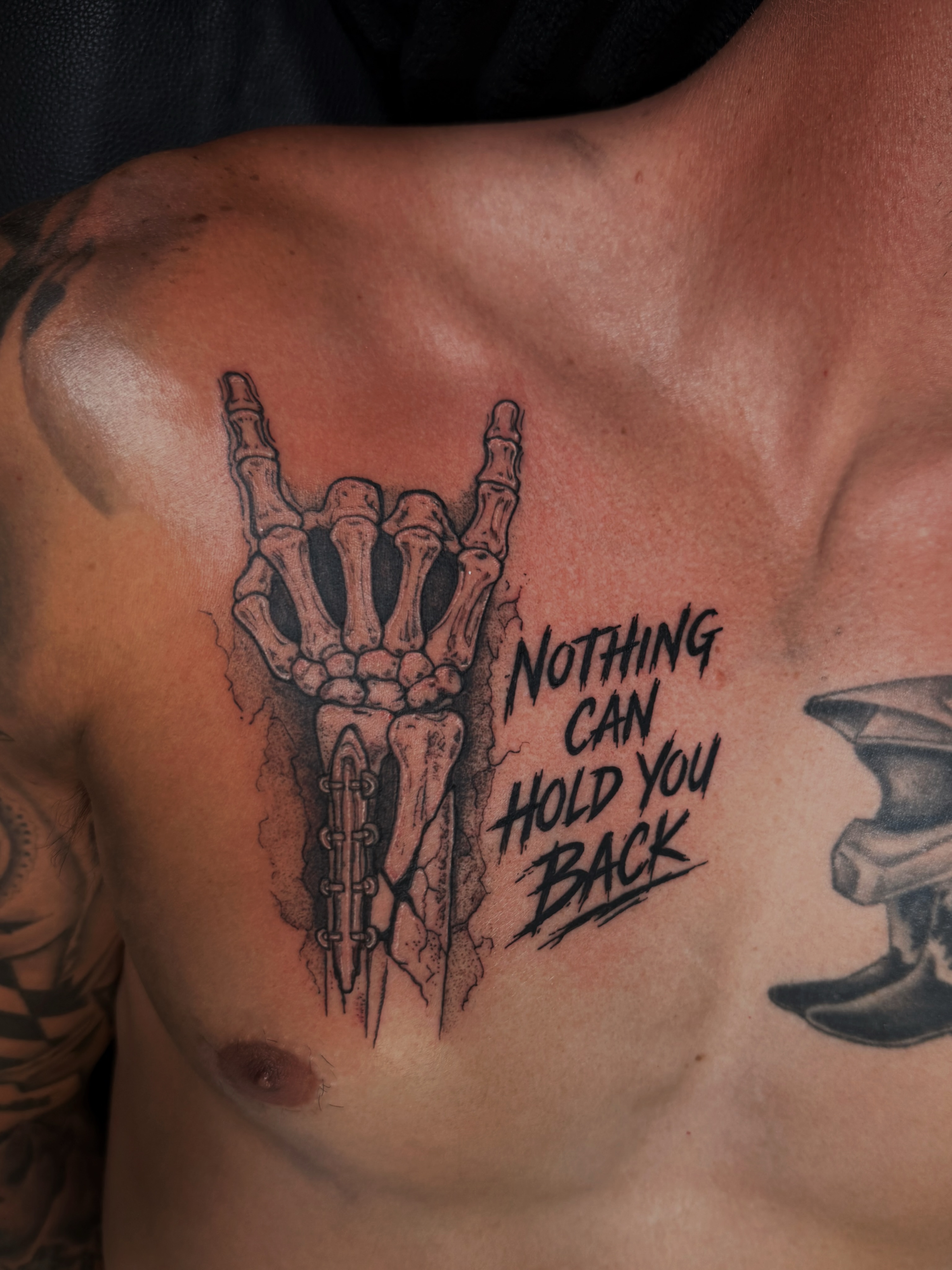Bone hand gesture black and grey tattoo on the chest by Kaylee Castleton, Tooele, Utah