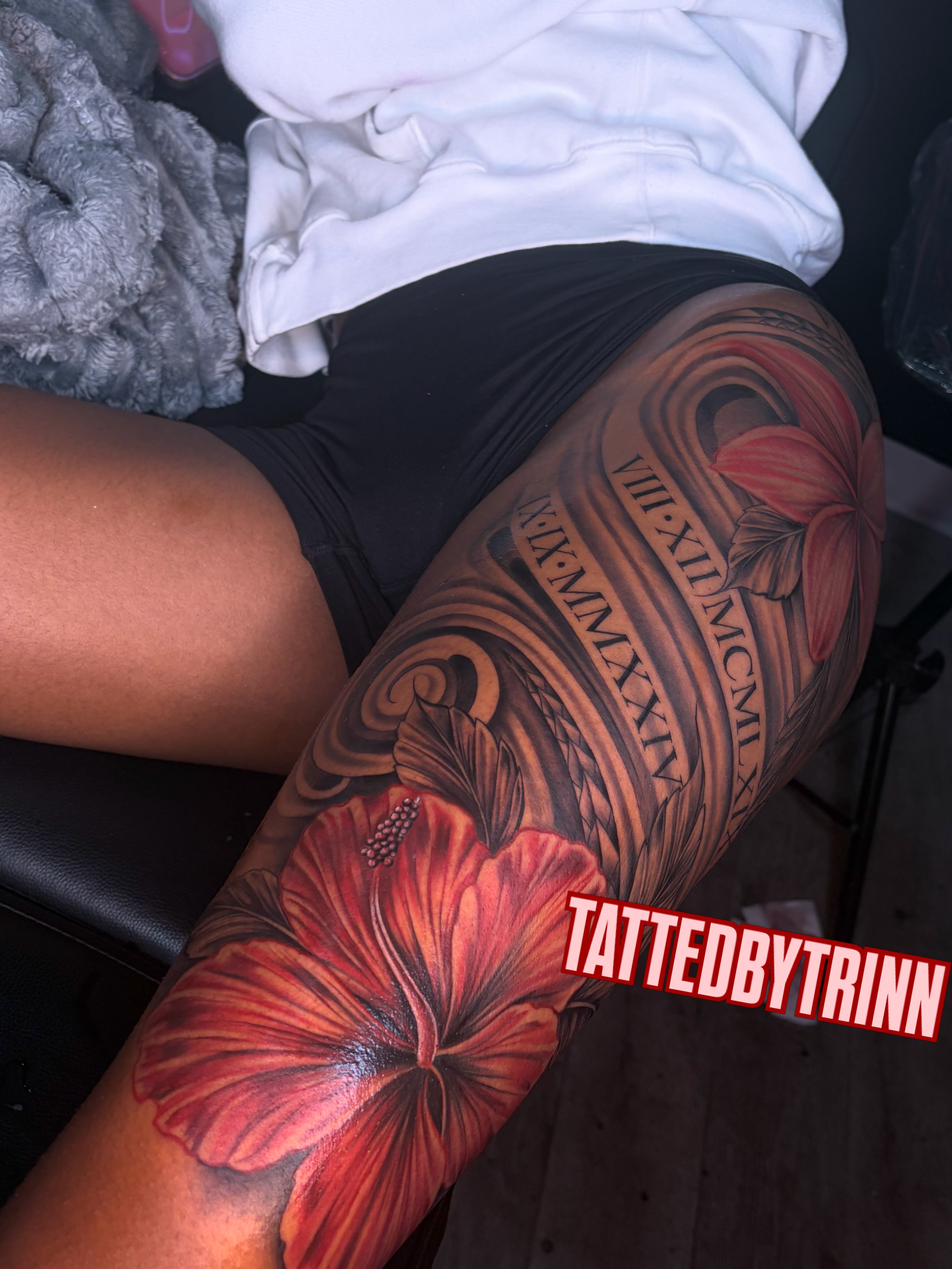 Red hibiscus flower realism tattoo on the thigh by Tattedbytrinn