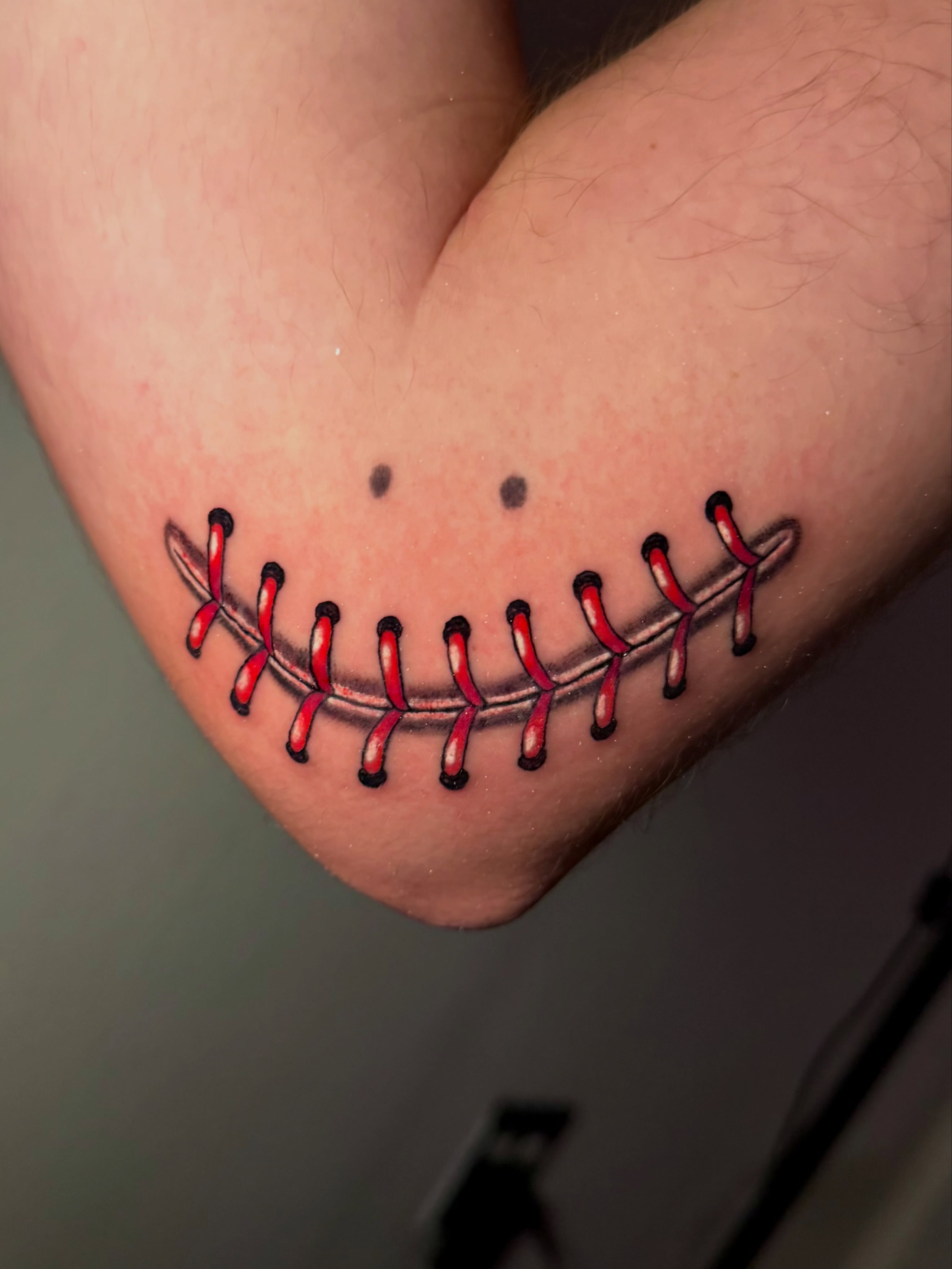 Baseball stitch realism tattoo on the forearm by Tess