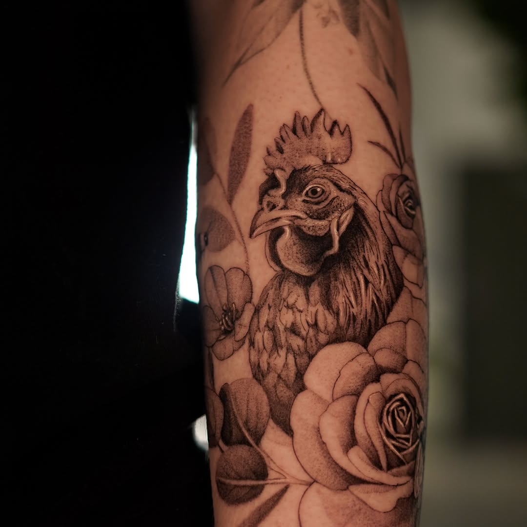 Rooster and roses realism tattoo on the forearm by Keely Thompson