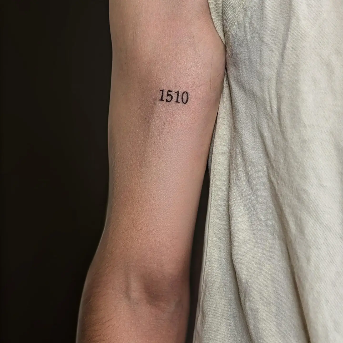 Number 1510 lettering script tattoo on the forearm by Tony