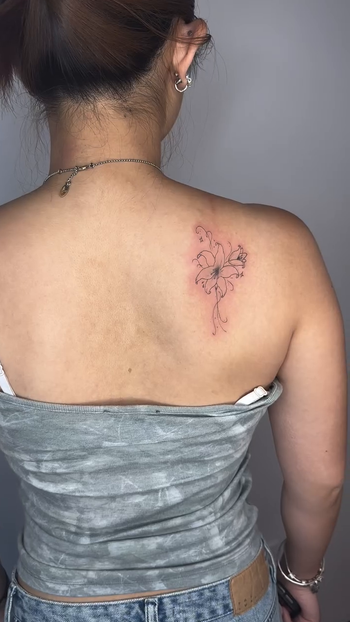 Lily flower fine line tattoo on the back by Cherry🥀