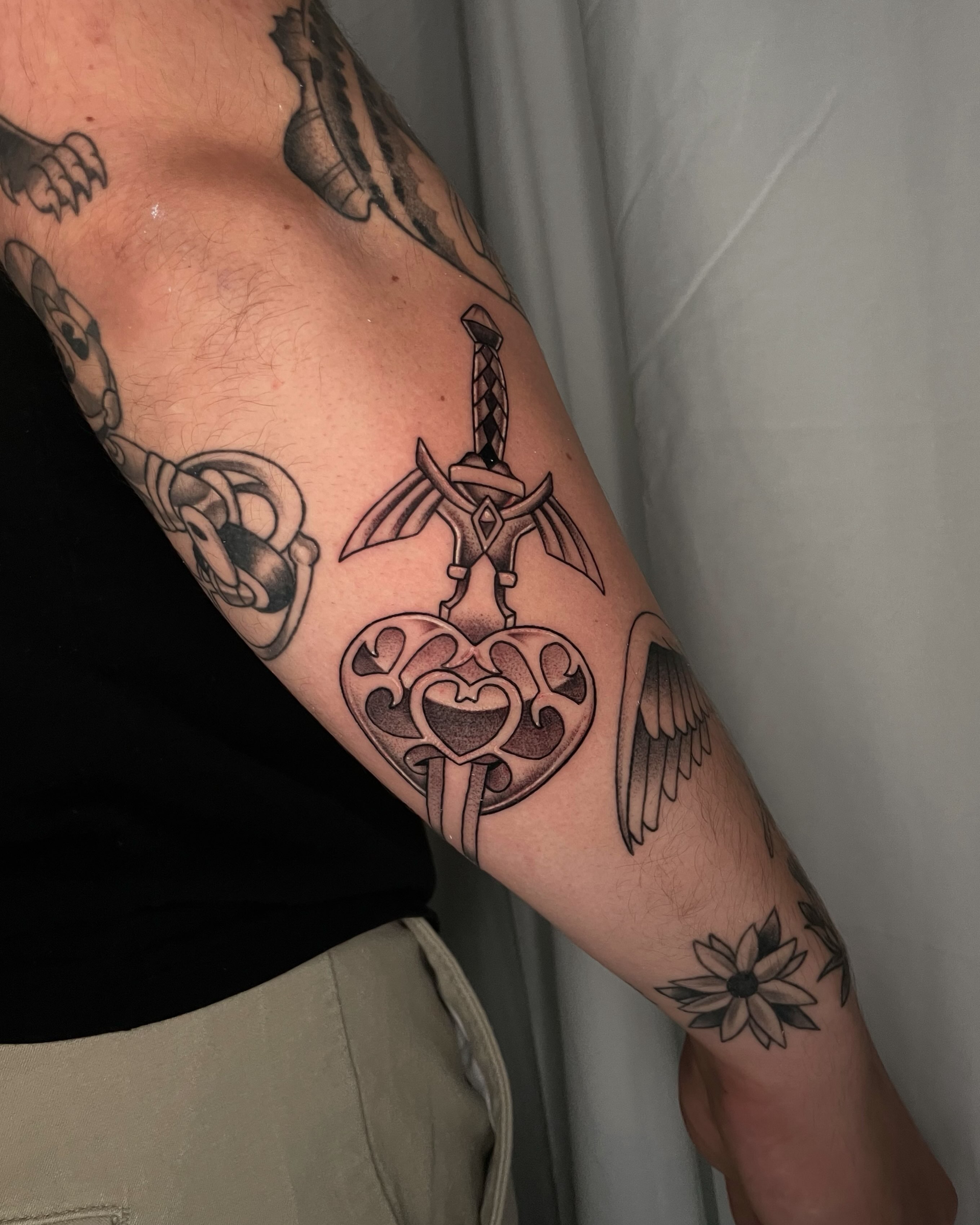 Heart with wings and sword black and grey tattoo on the forearm by Sam chase, Naperville, Illinois