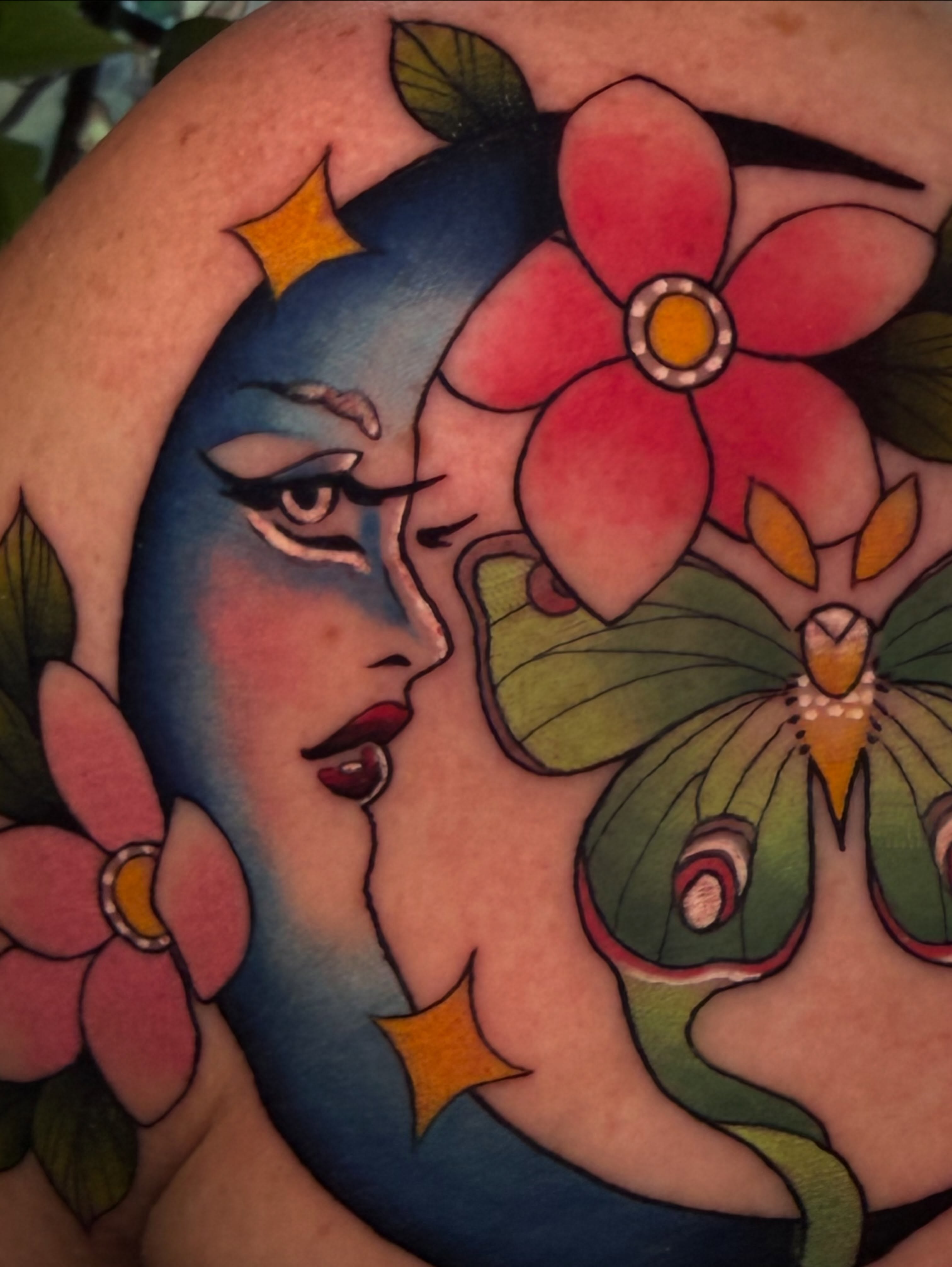 Woman with flowers American traditional tattoo on the upper arm by Reagan Mauldin