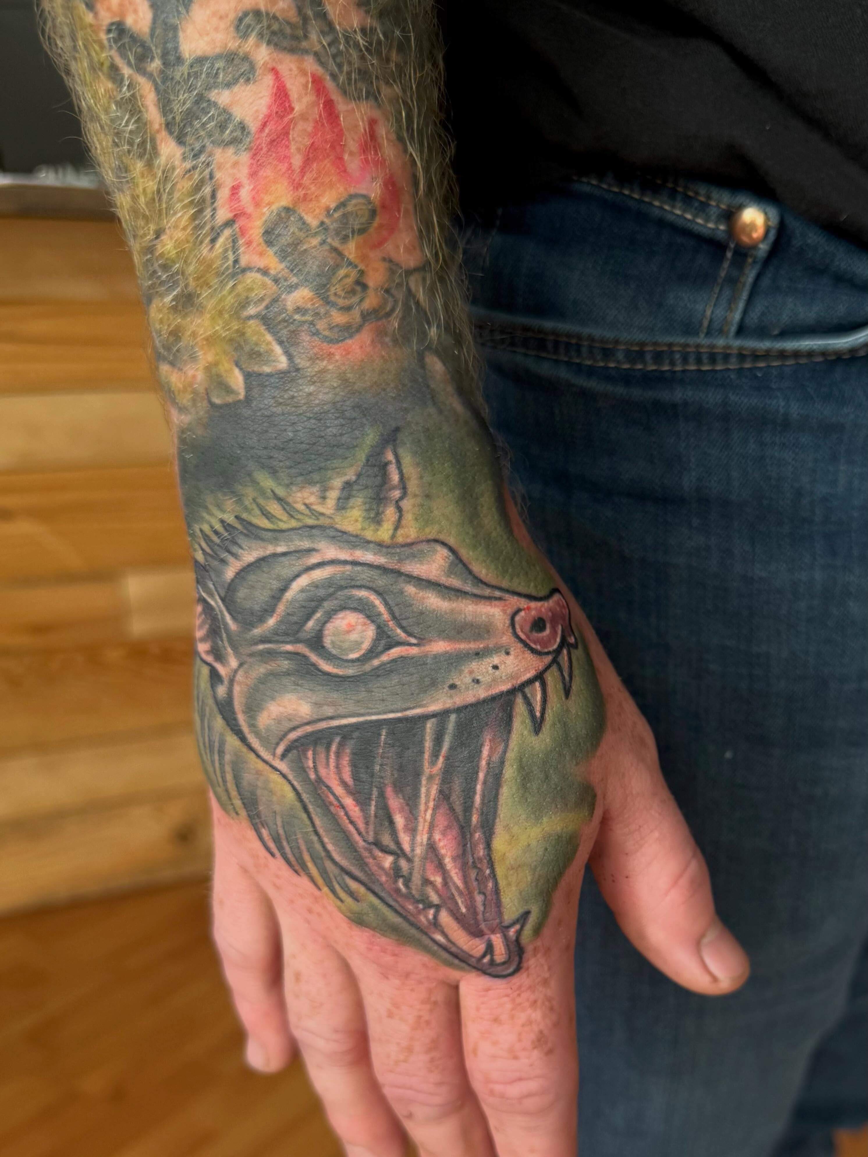 Fangs and eyes American traditional tattoo on the hand by Aaron Ysidro
