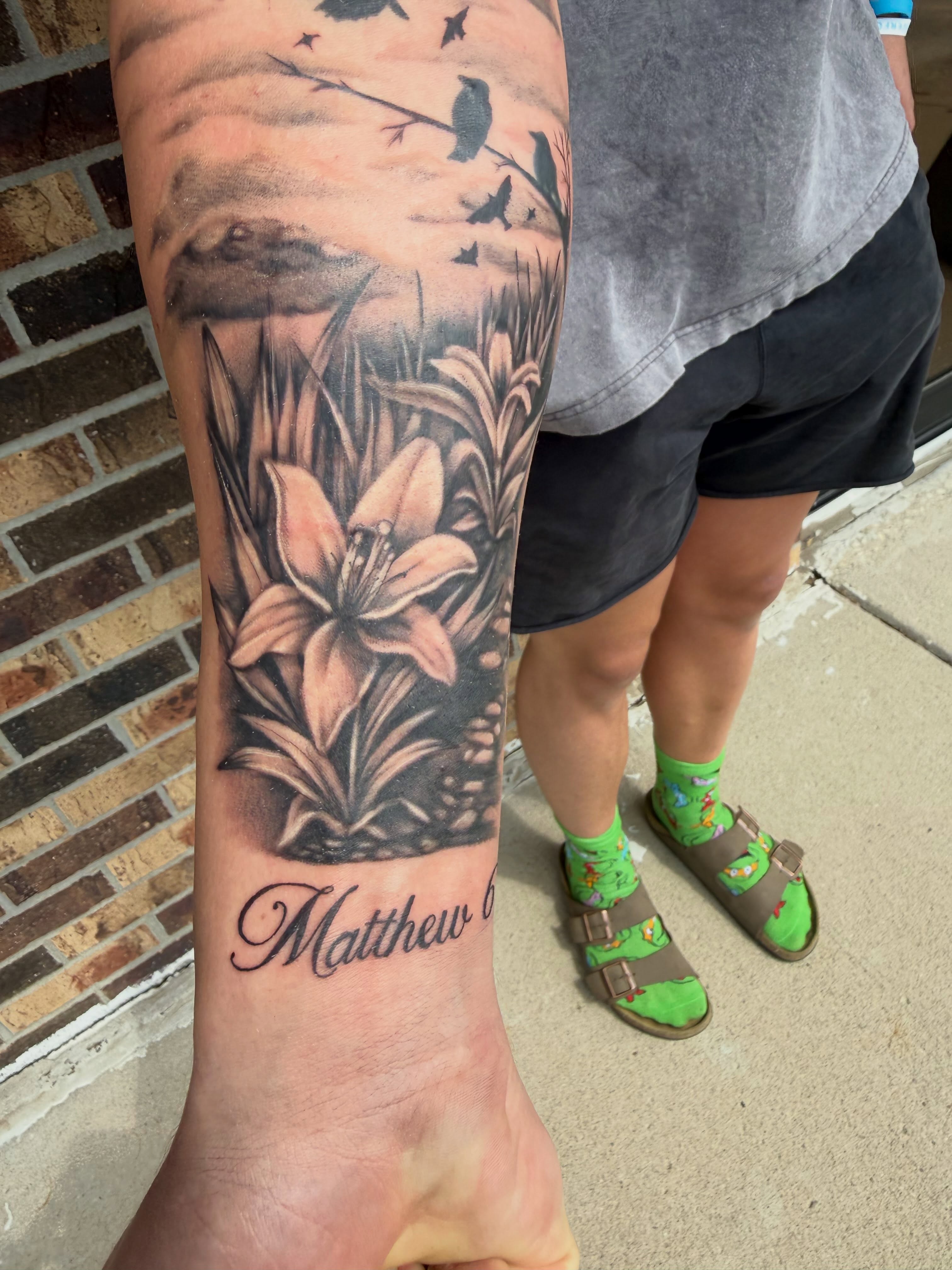 Lilies and birds realism tattoo on the forearm by Lauren Horness