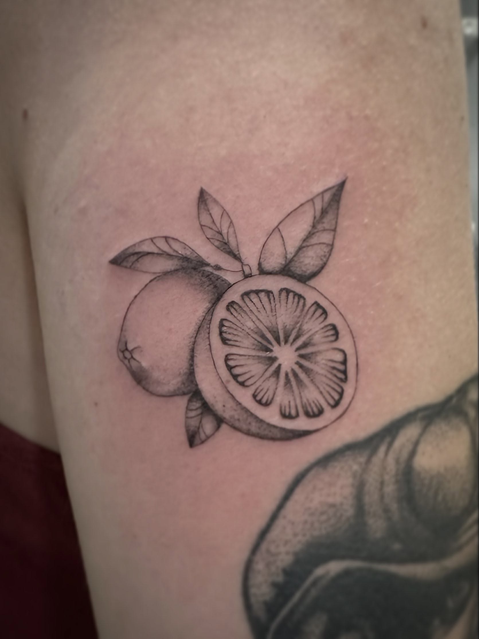 Orange black and grey tattoo on the thigh by Bell