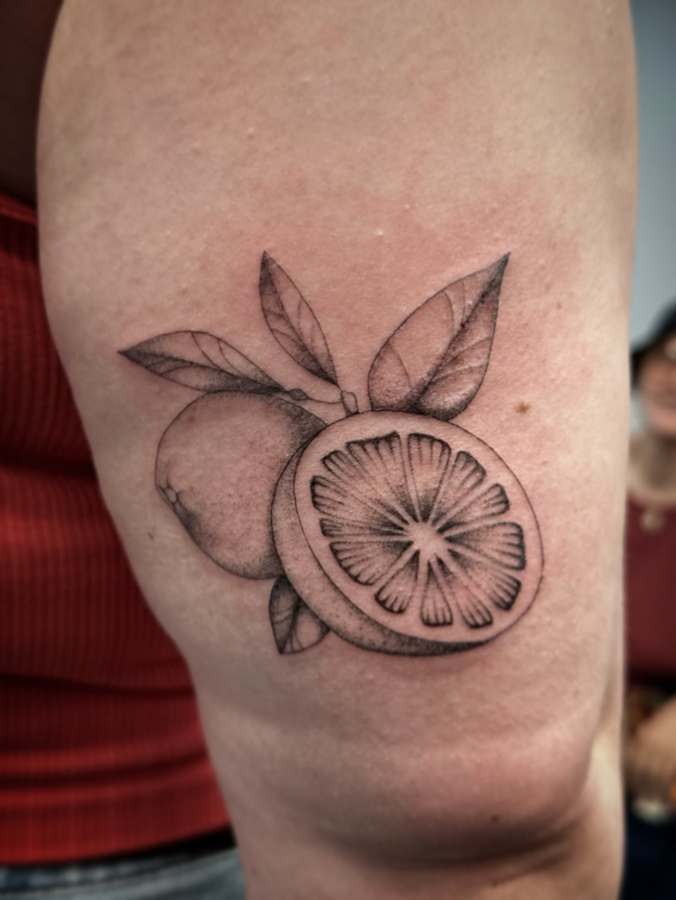 Orange slice realism tattoo on the forearm by Bell