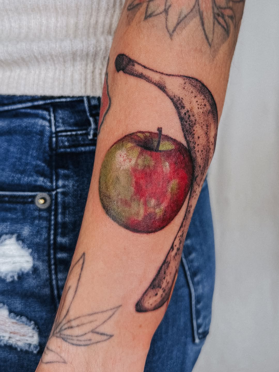Apple and banana neo-traditional tattoo on the forearm by Lucy Yin