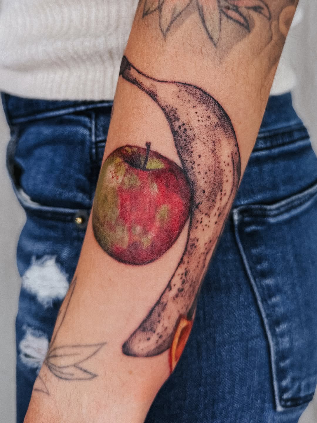 Apple and banana watercolor tattoo on the forearm by Lucy Yin