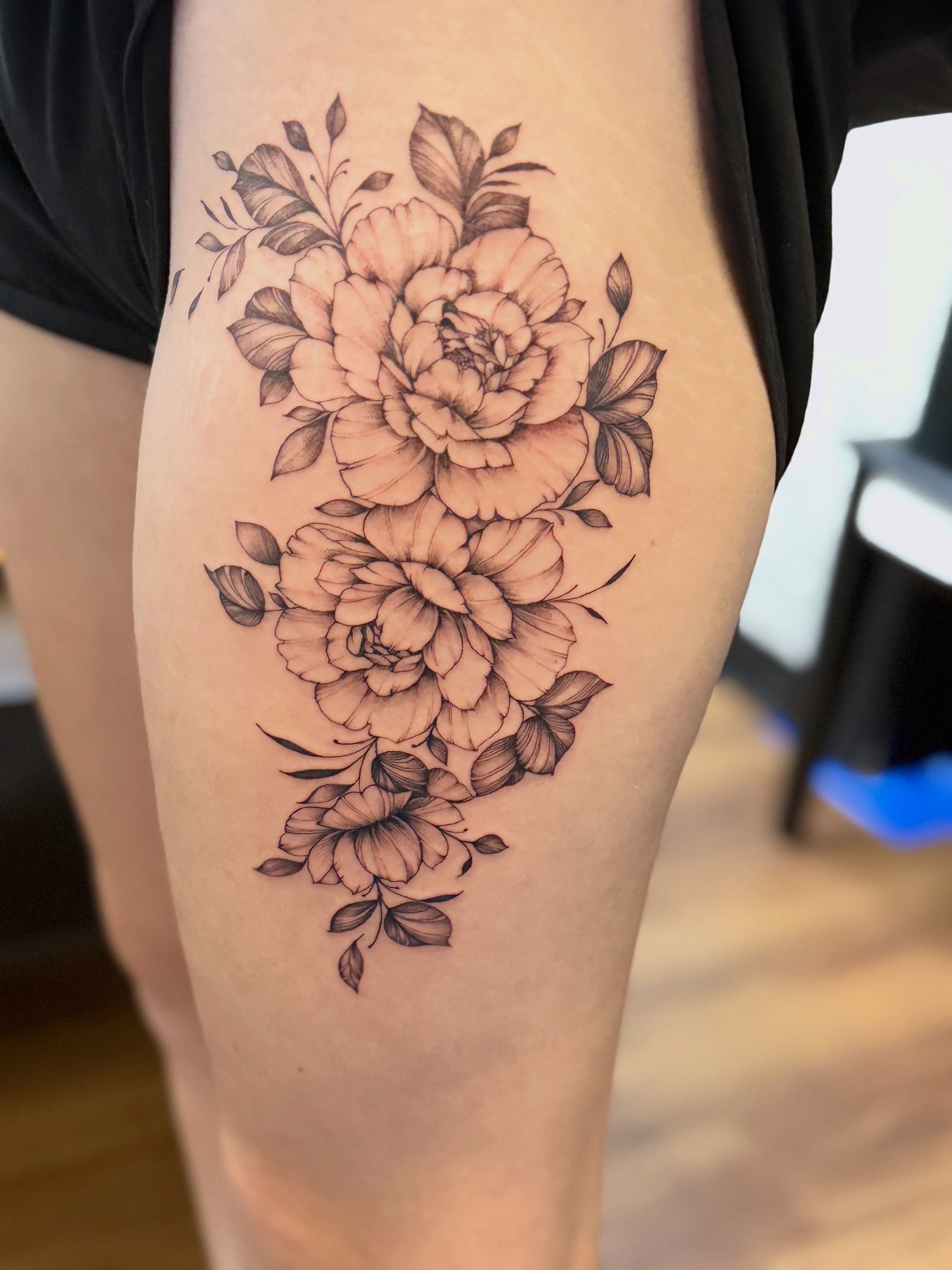Peony bouquet black and grey tattoo on the thigh by Tetiana