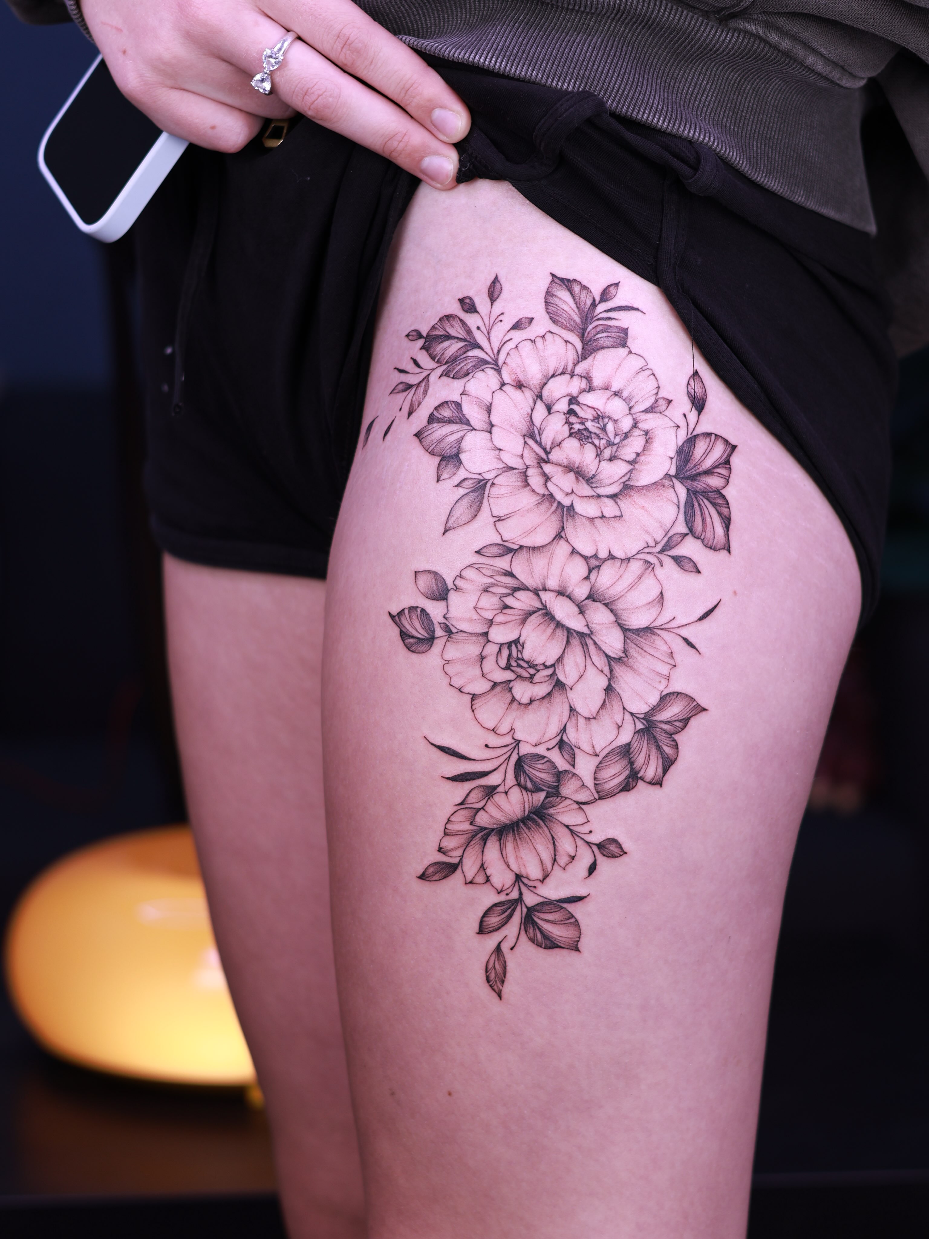 Peony bouquet black and grey tattoo on the thigh by Tetiana