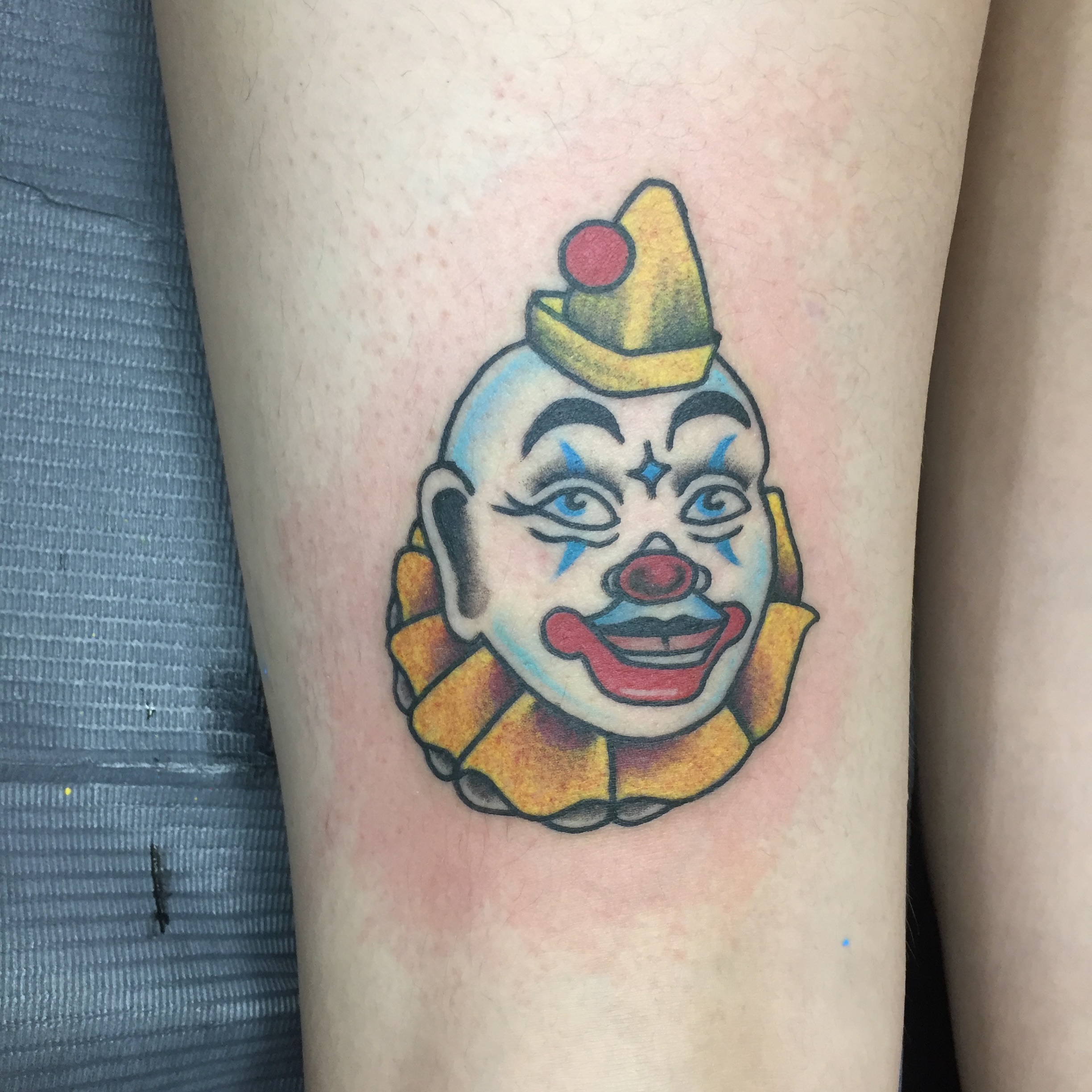 Clown face American traditional tattoo on the forearm by Ramsie Segura-Andrews