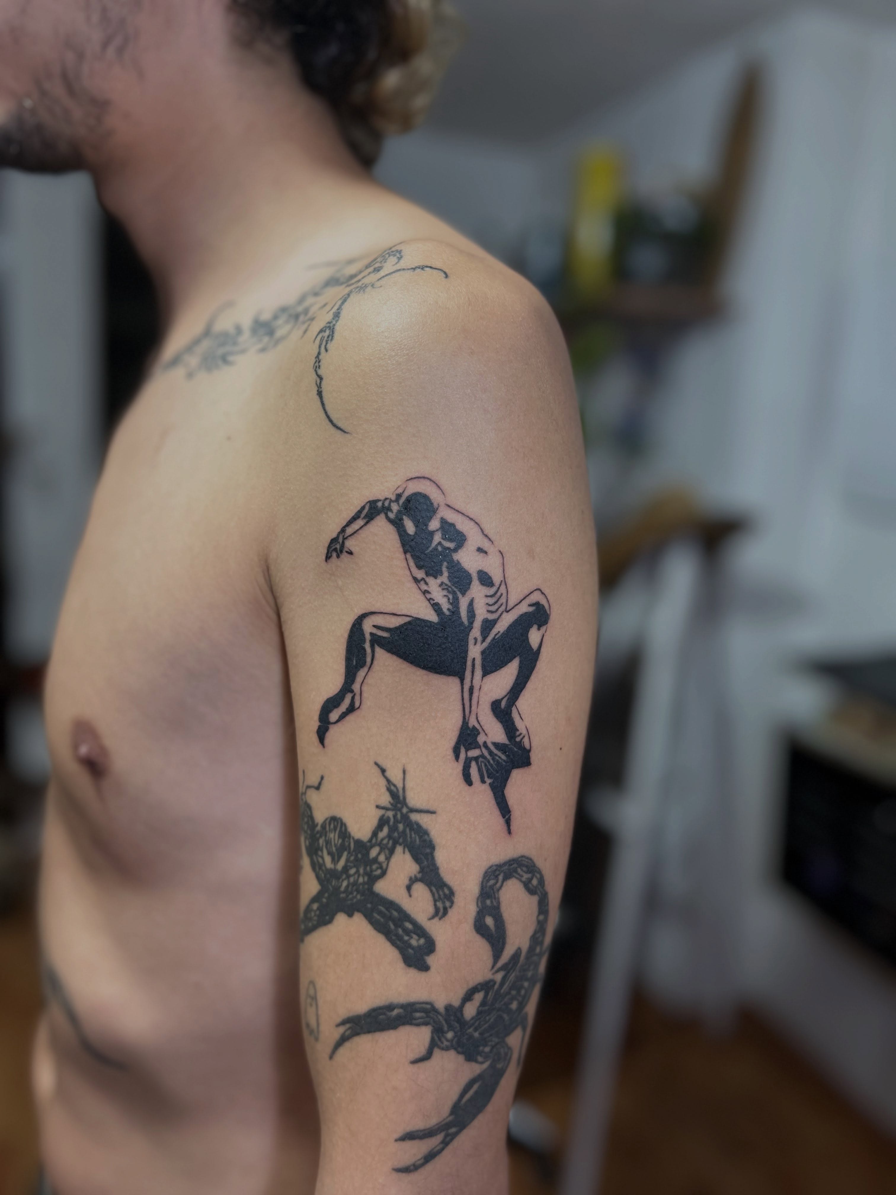 Superhero black and grey tattoo on the shoulder by Barro