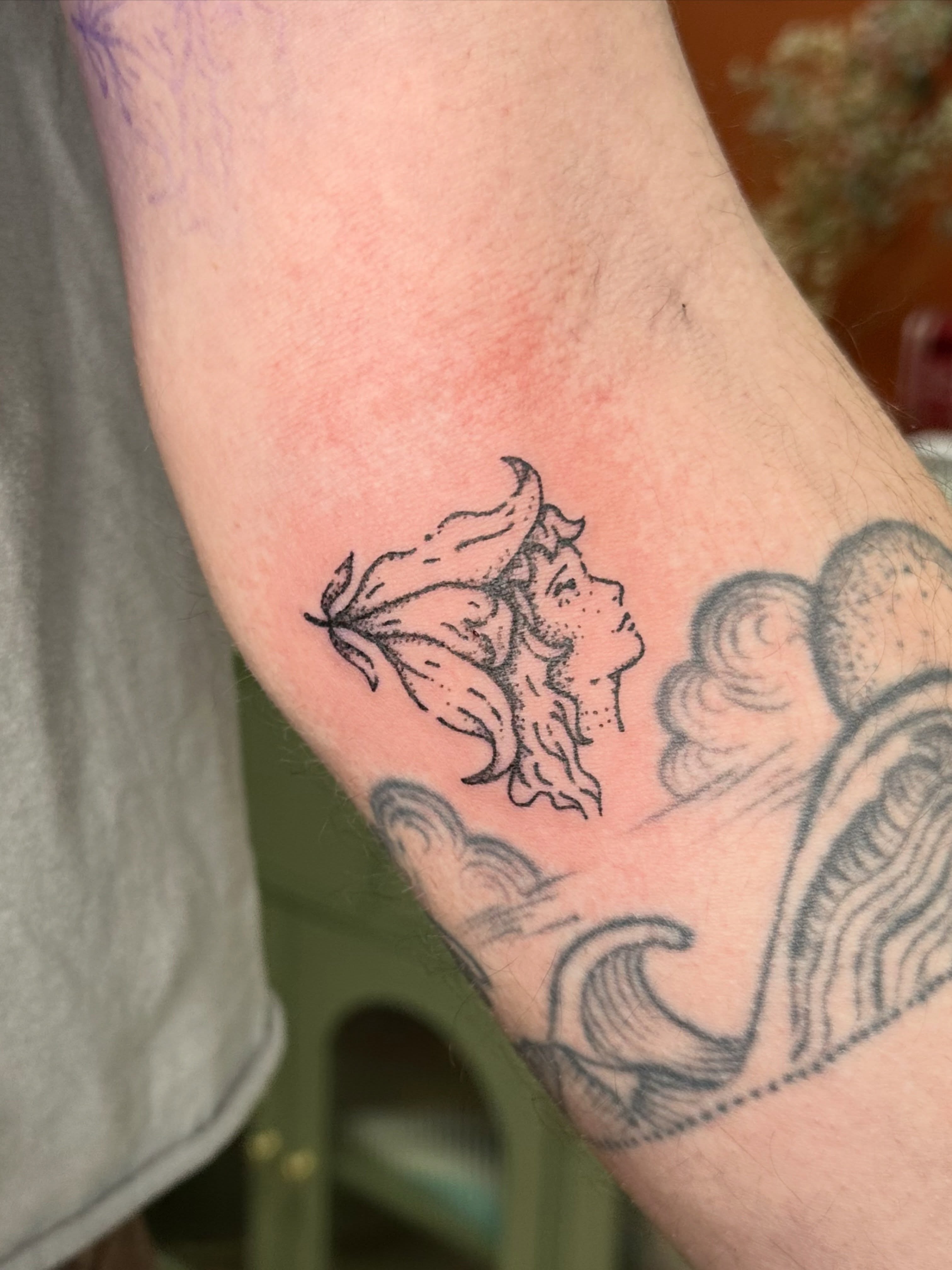 Woman's profile with lily black and grey tattoo on the forearm by Fleur ๐ฅ