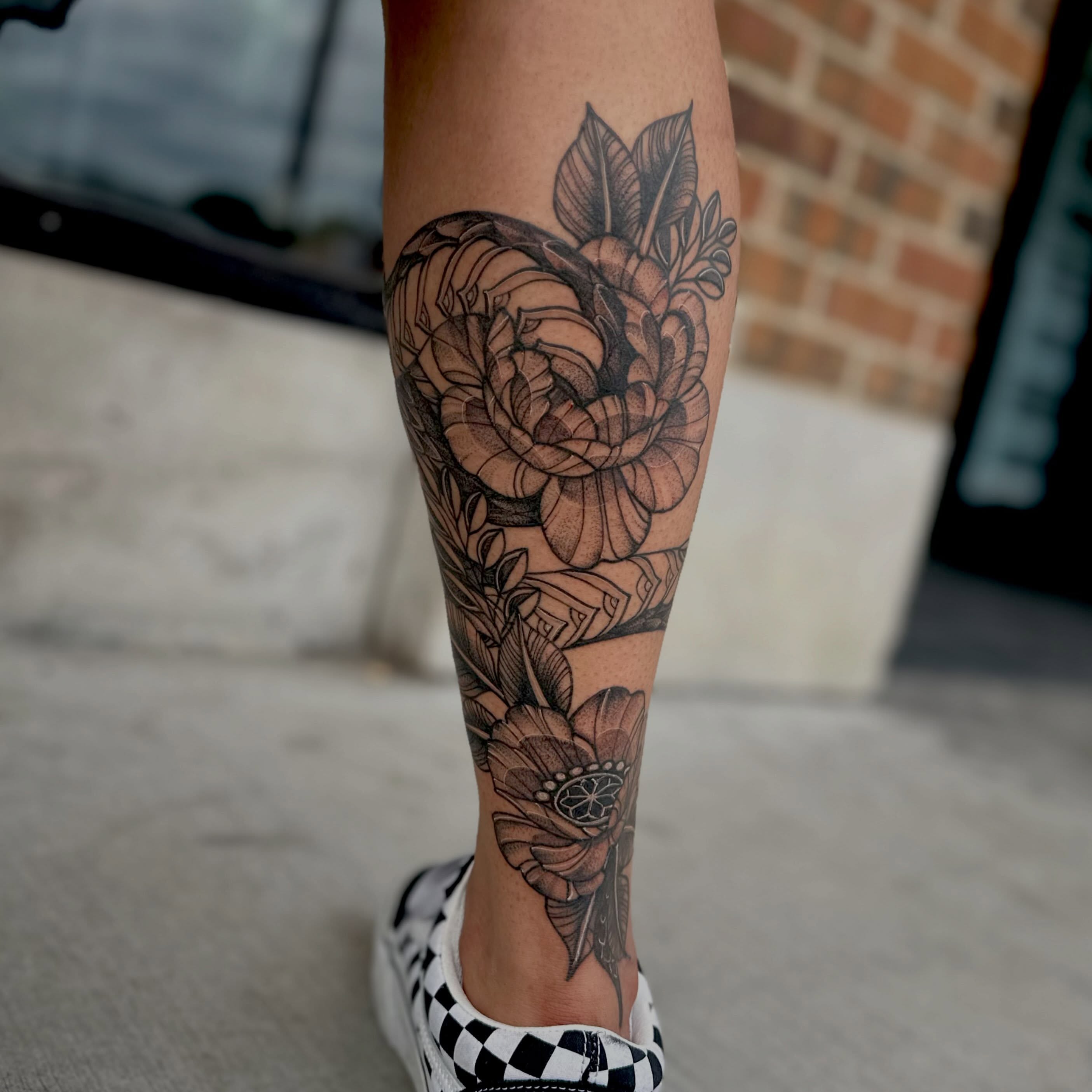 Floral bouquet realism tattoo on the calf by Leeuh Vandever