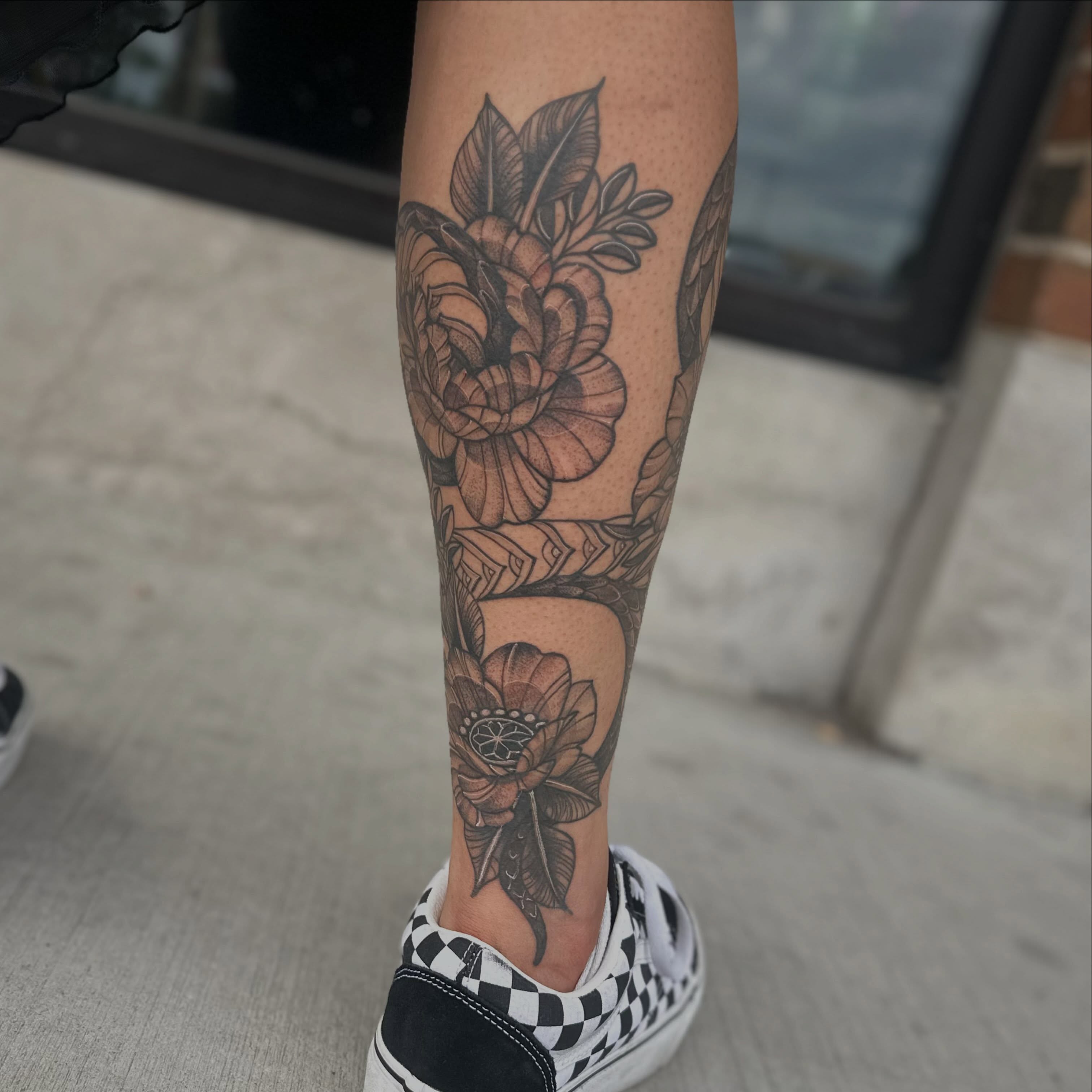Floral design black and grey tattoo on the calf by Leeuh Vandever