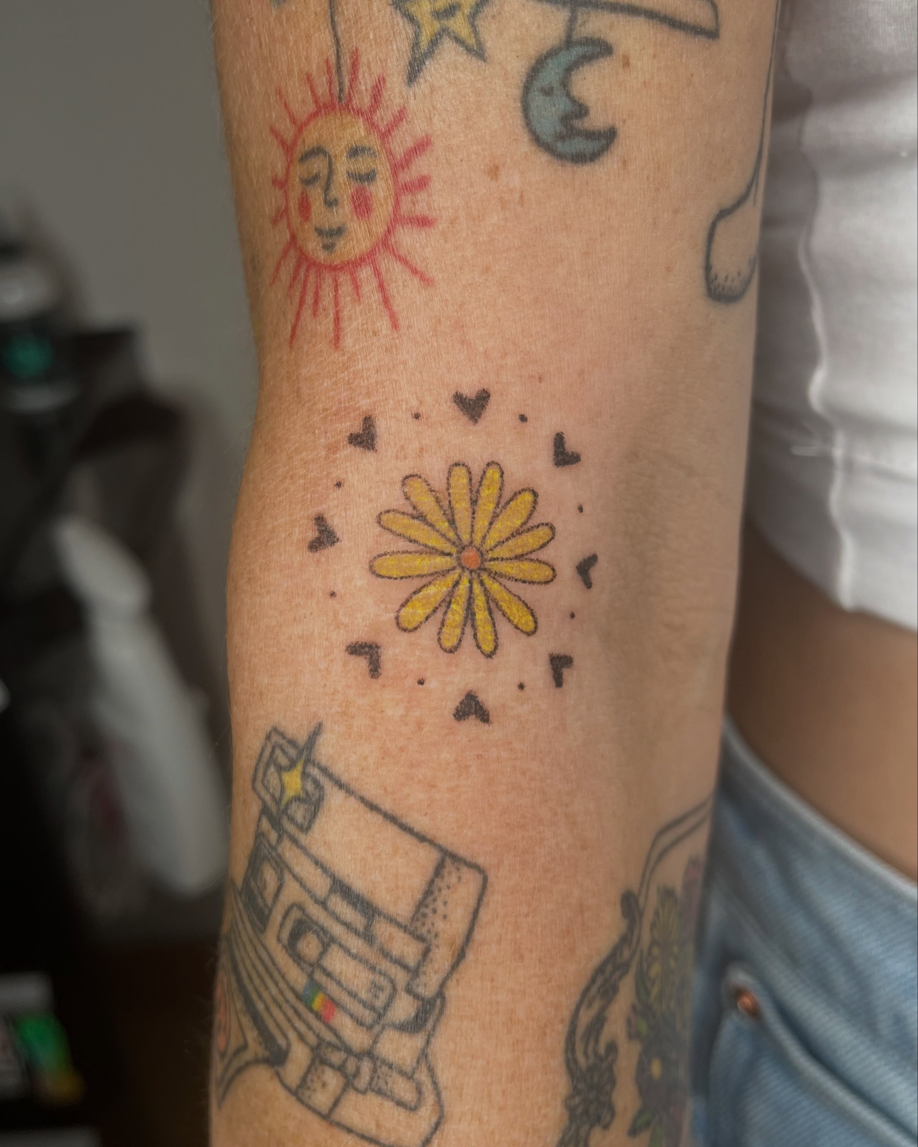 Yellow daisy dotwork tattoo on the forearm by Jenna