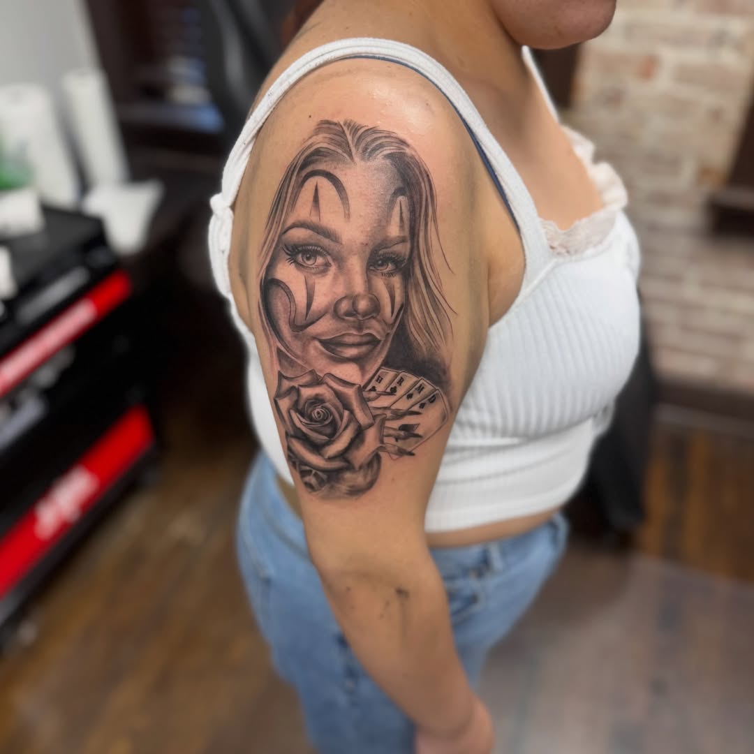 Woman's face with rose and cards realism tattoo on the upper arm by Willi Tattoos👹