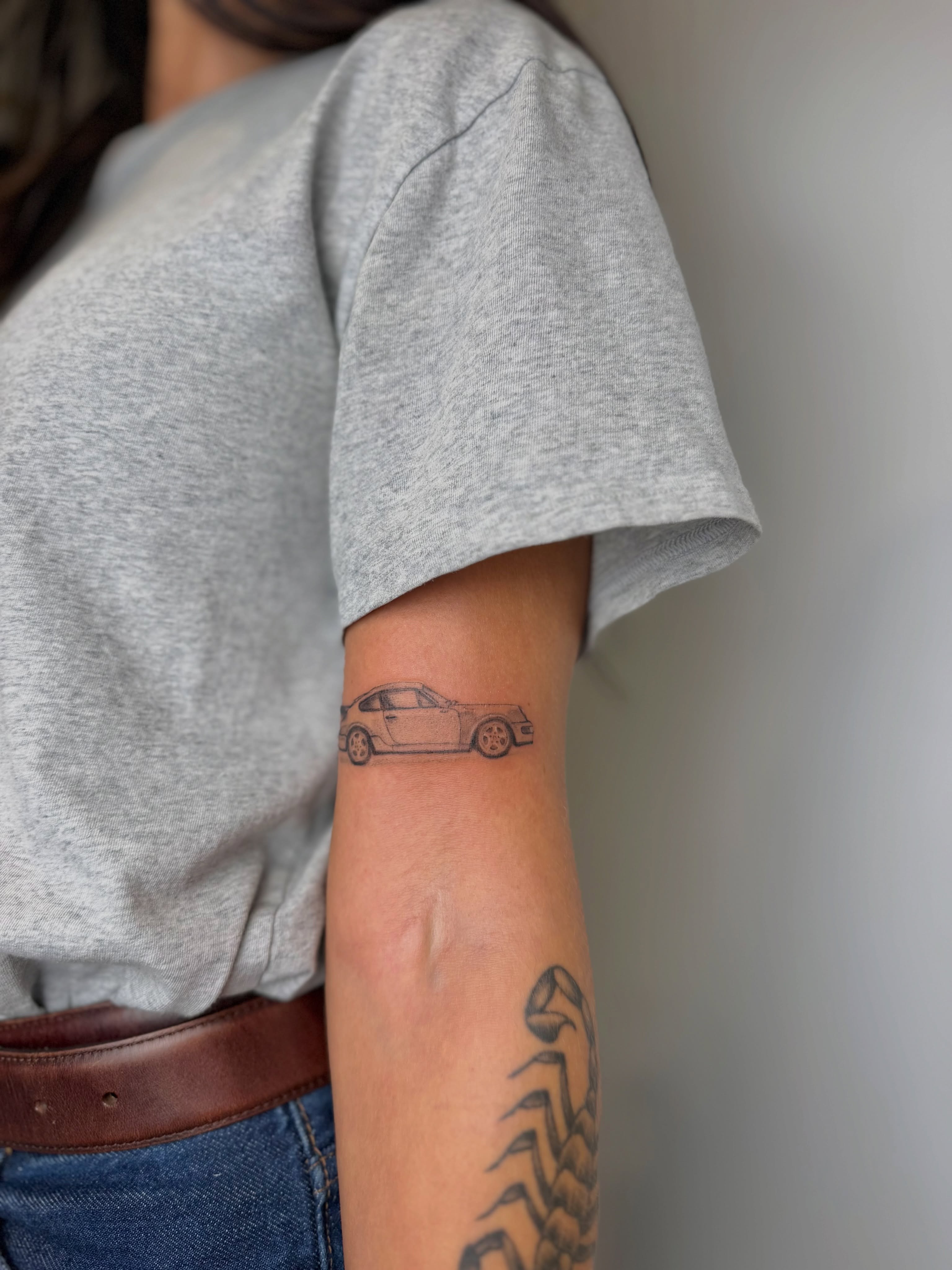 Car black and grey tattoo on the forearm by Mackenzie