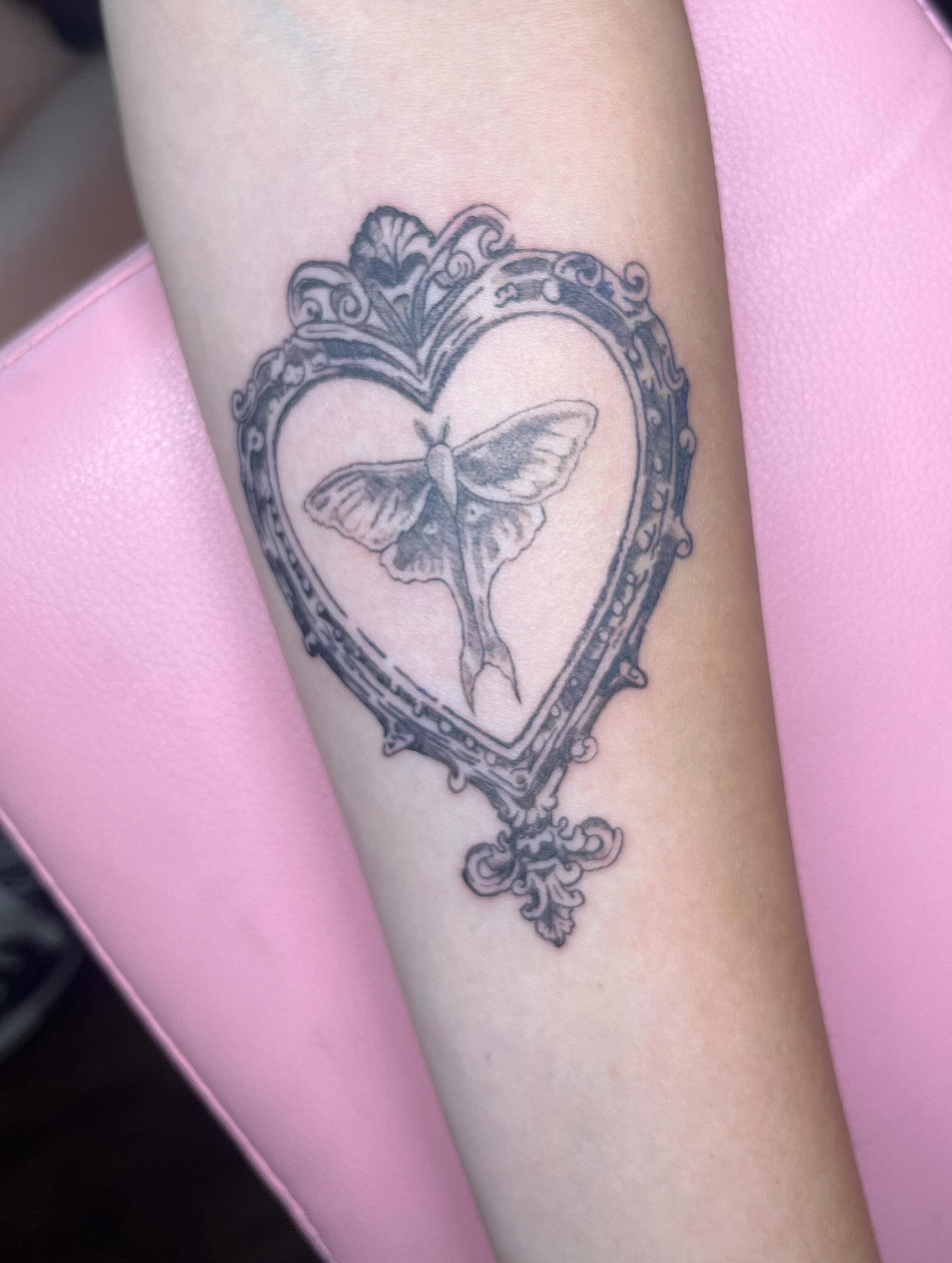 Heart with moth black and grey tattoo on the forearm by Jazzy