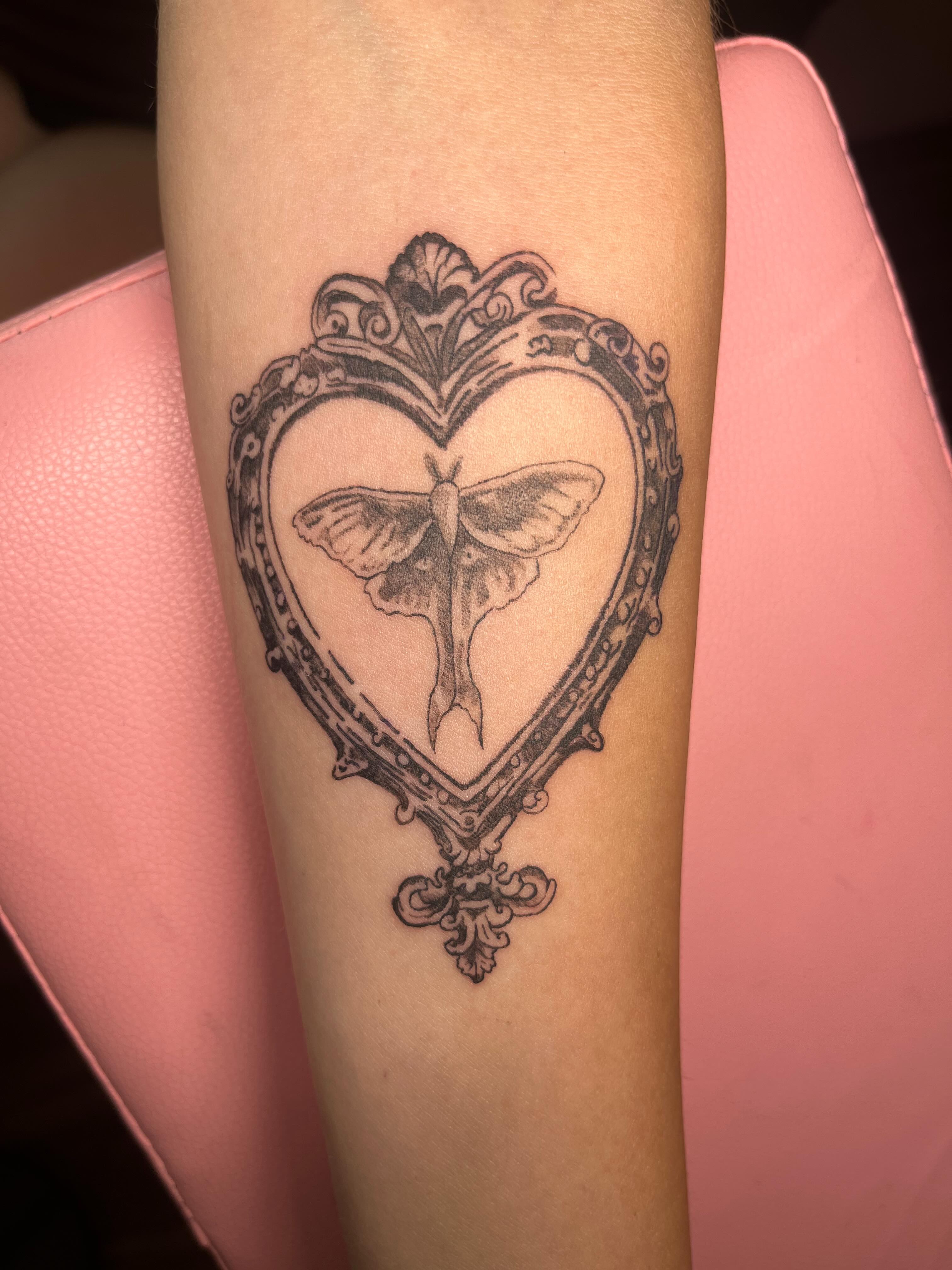 Heart with moth black and grey tattoo on the forearm by Jazzy