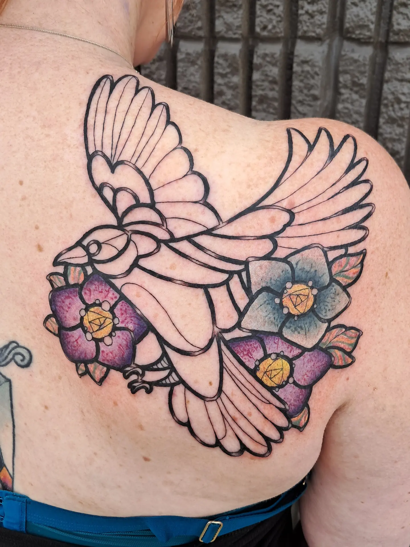 Bird and flowers American traditional tattoo on the shoulder by Erika Hollingsworth