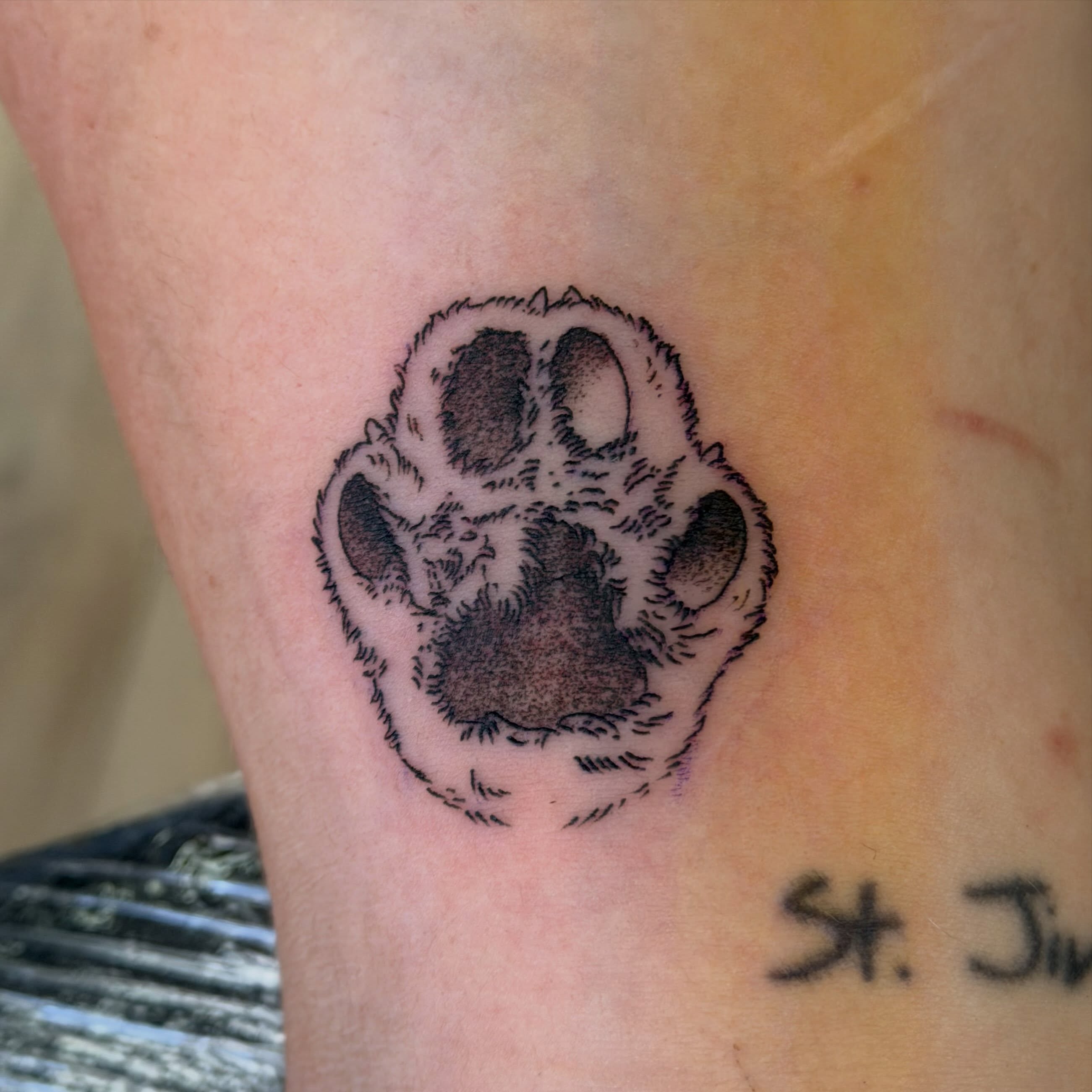 Paw print black and grey tattoo on the forearm by Stvn Geyer, Urbandale, Iowa