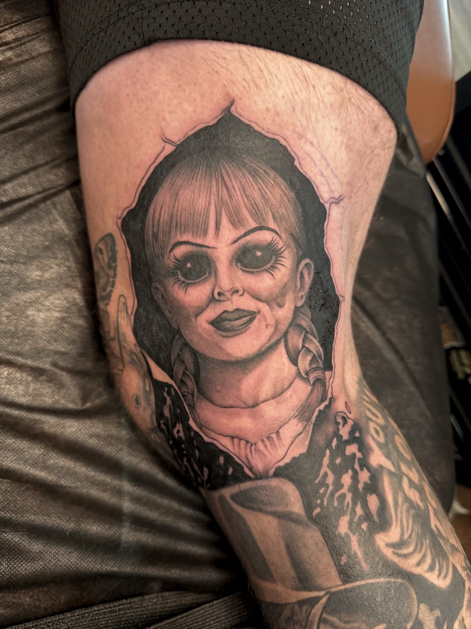 Chucky doll realism tattoo on the thigh by Sarah Margaret