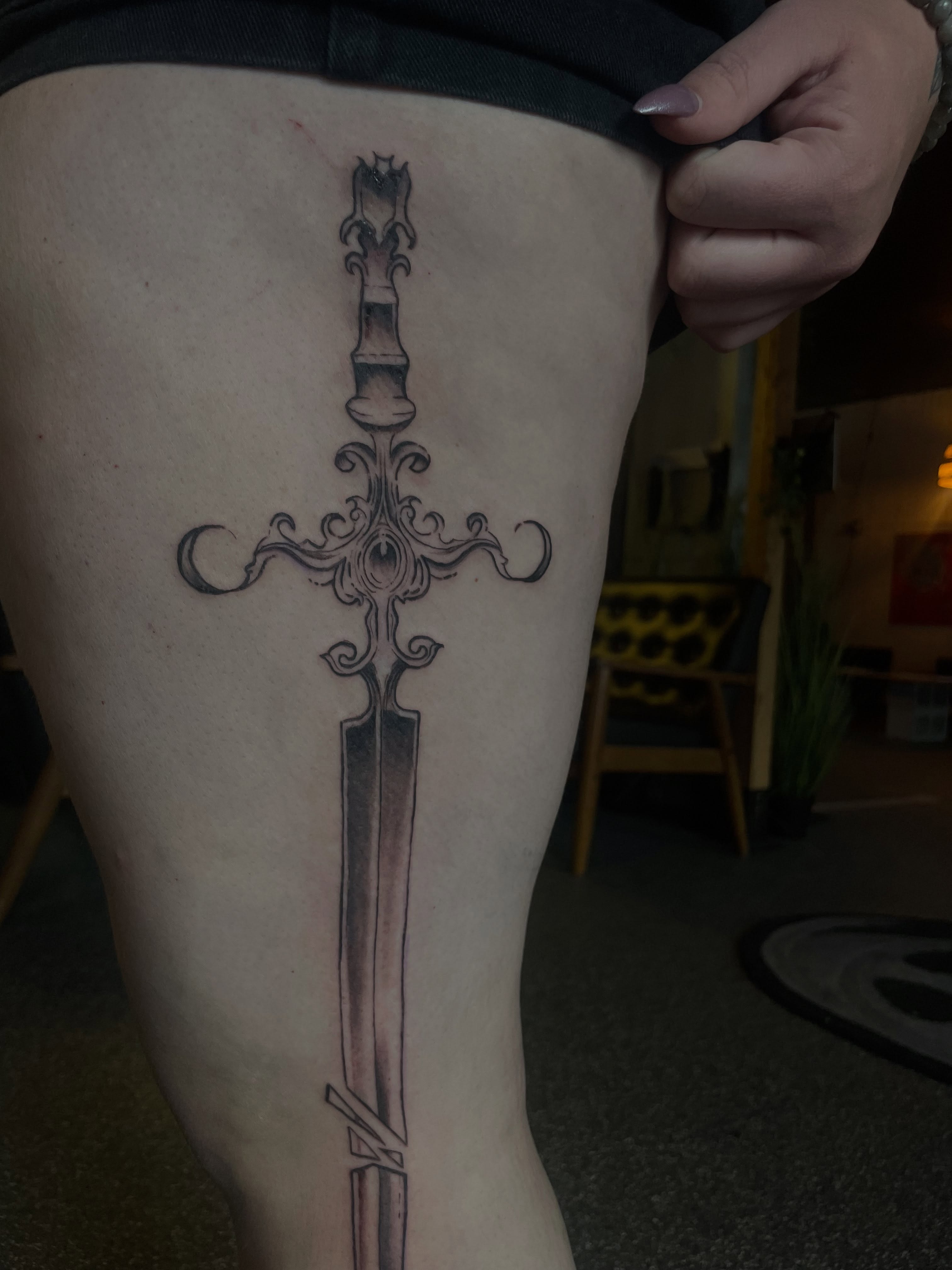 Sword geometric tattoo on the thigh by Trinity