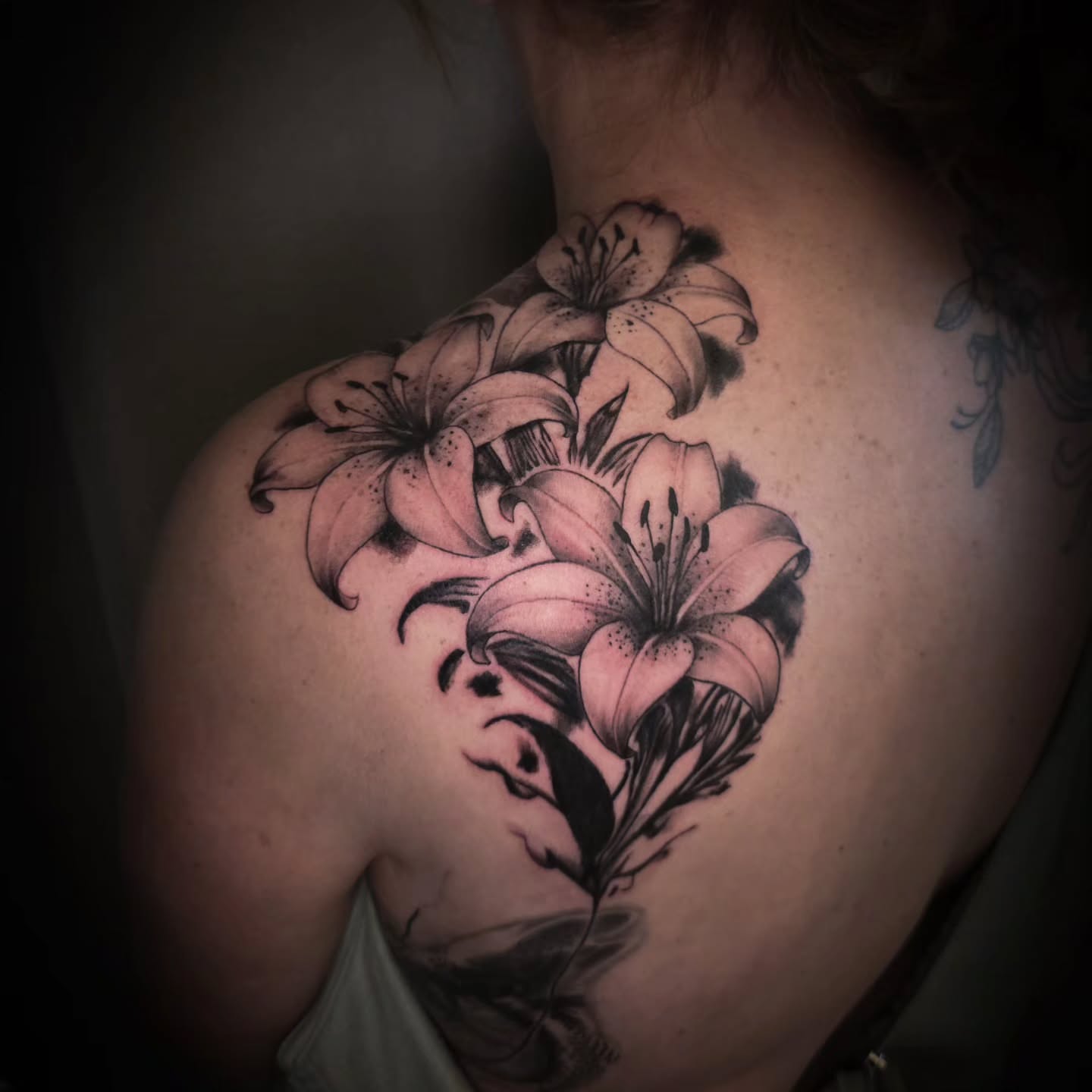 Lilies black and grey tattoo on the shoulder by John Christo Blake