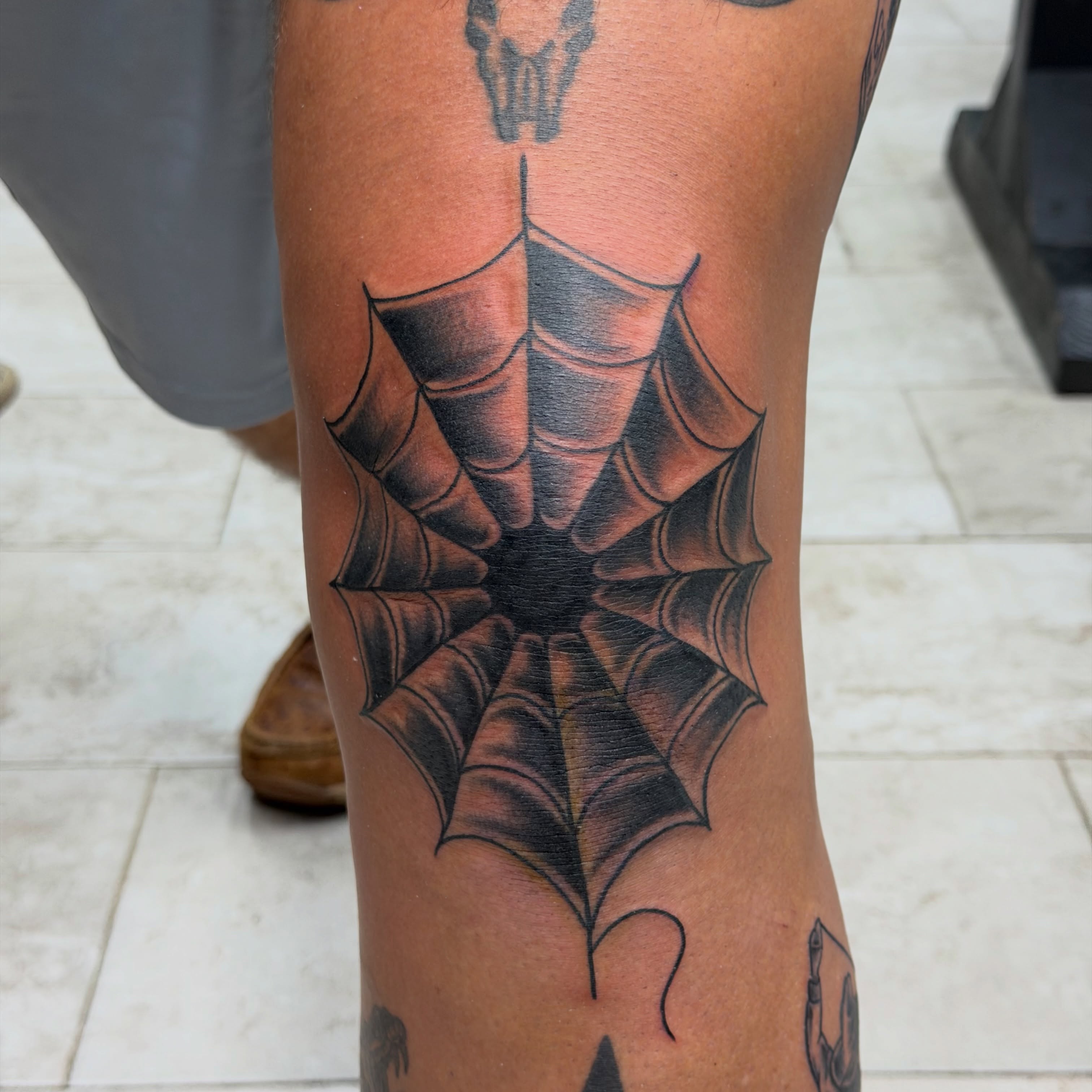 Spider web black and grey tattoo on the calf by Squid