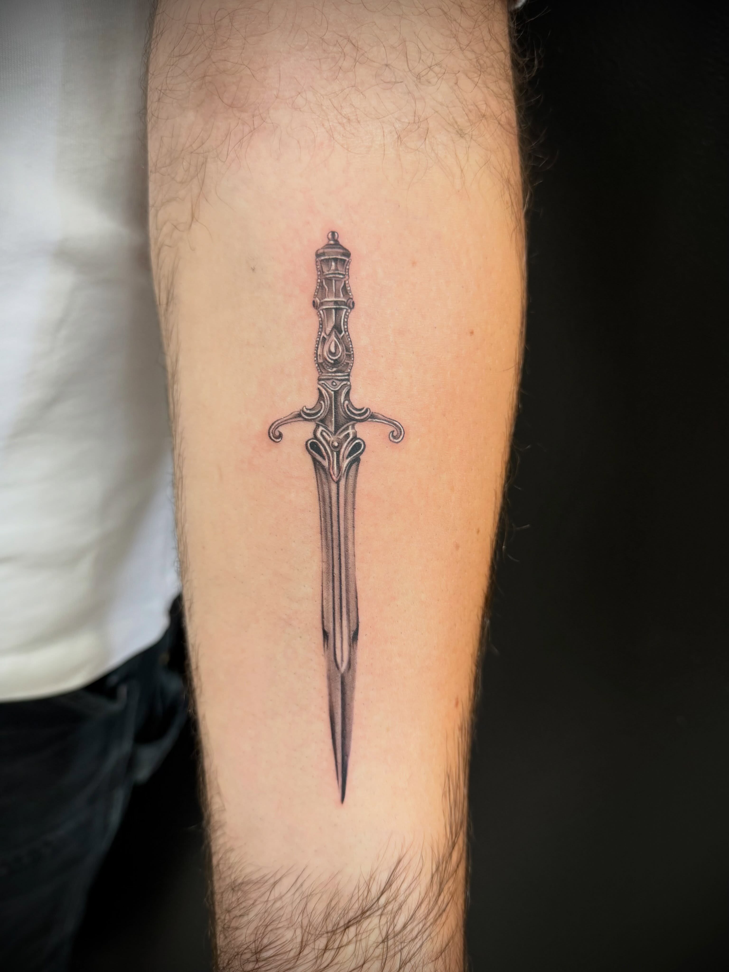 Sword black and grey tattoo on the forearm by Diana Guillette