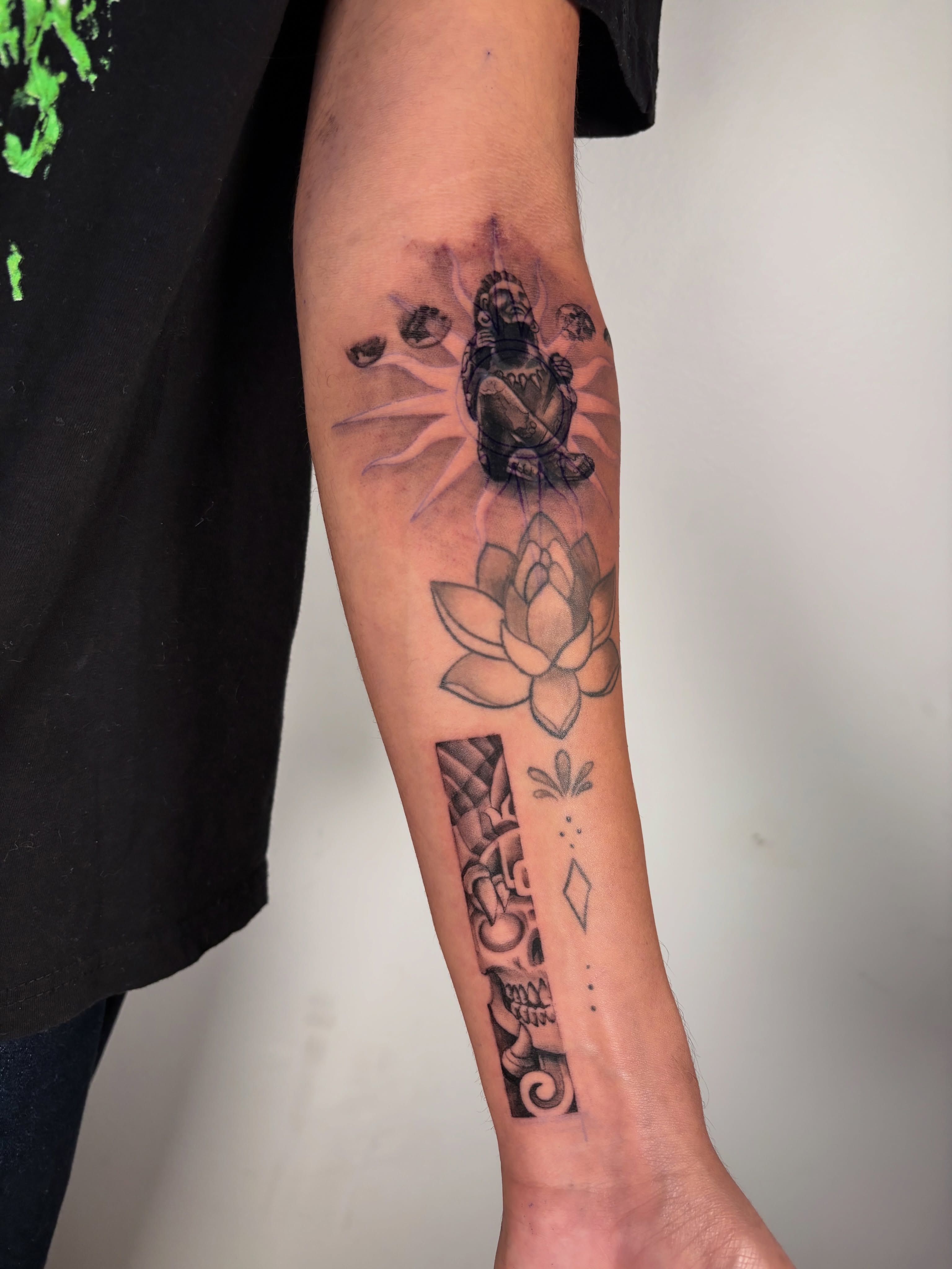 Lotus flower and Buddha geometric tattoo on the forearm by Dani