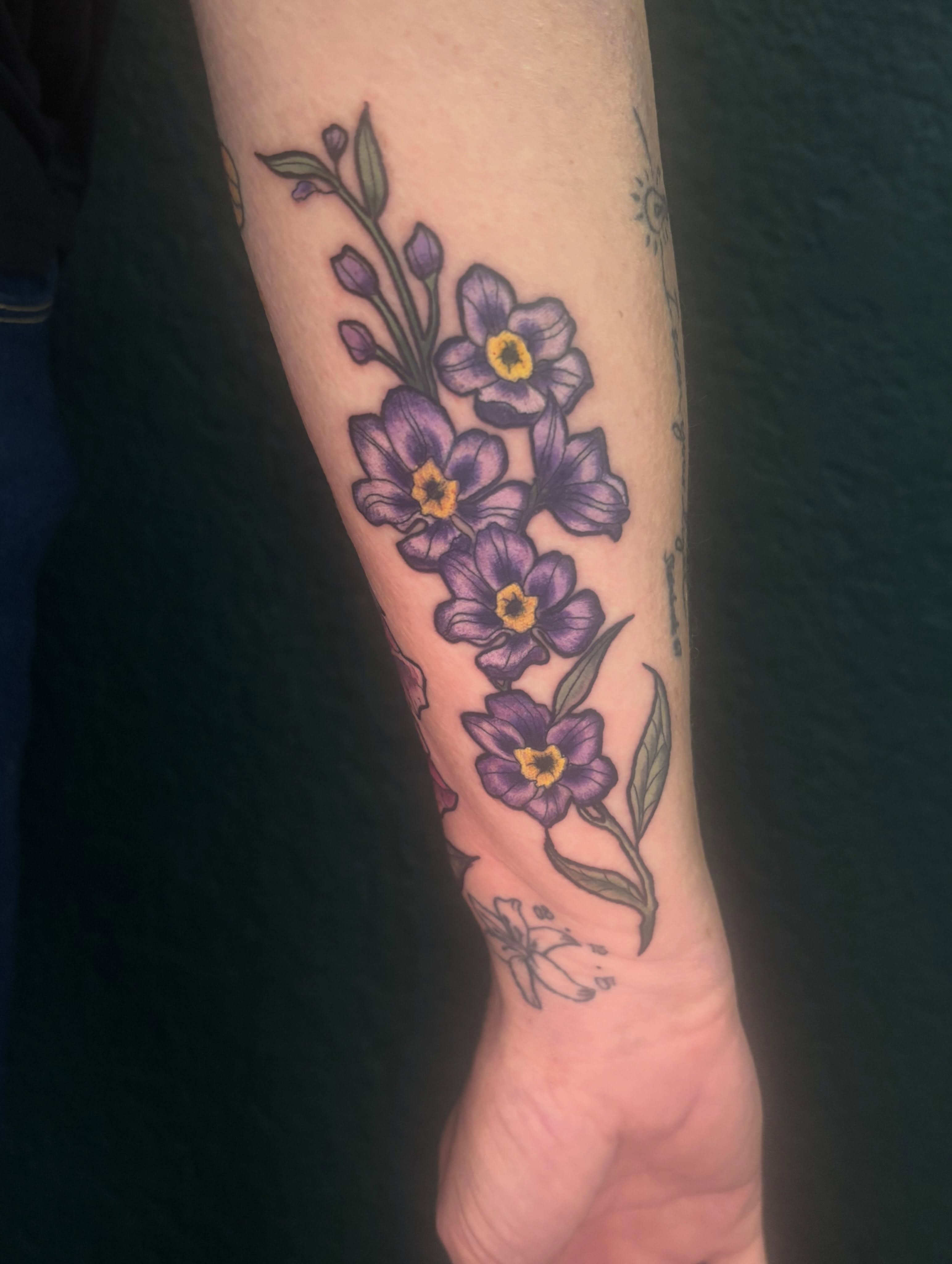 Purple flowers dotwork tattoo on the forearm by Emma ๐
