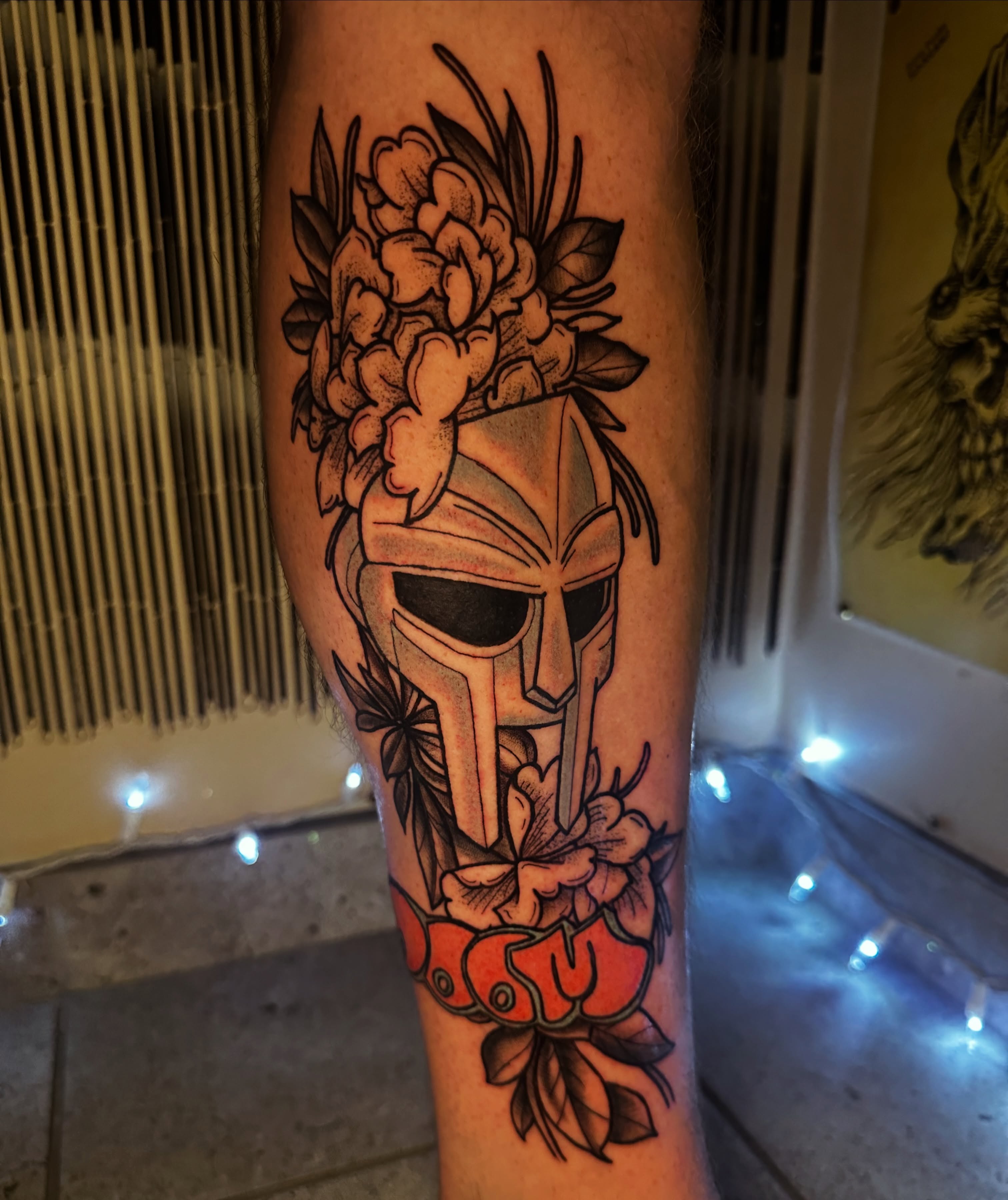 Spartan helmet with flowers American traditional tattoo on the forearm by Drew’s Tattoos (NH)
