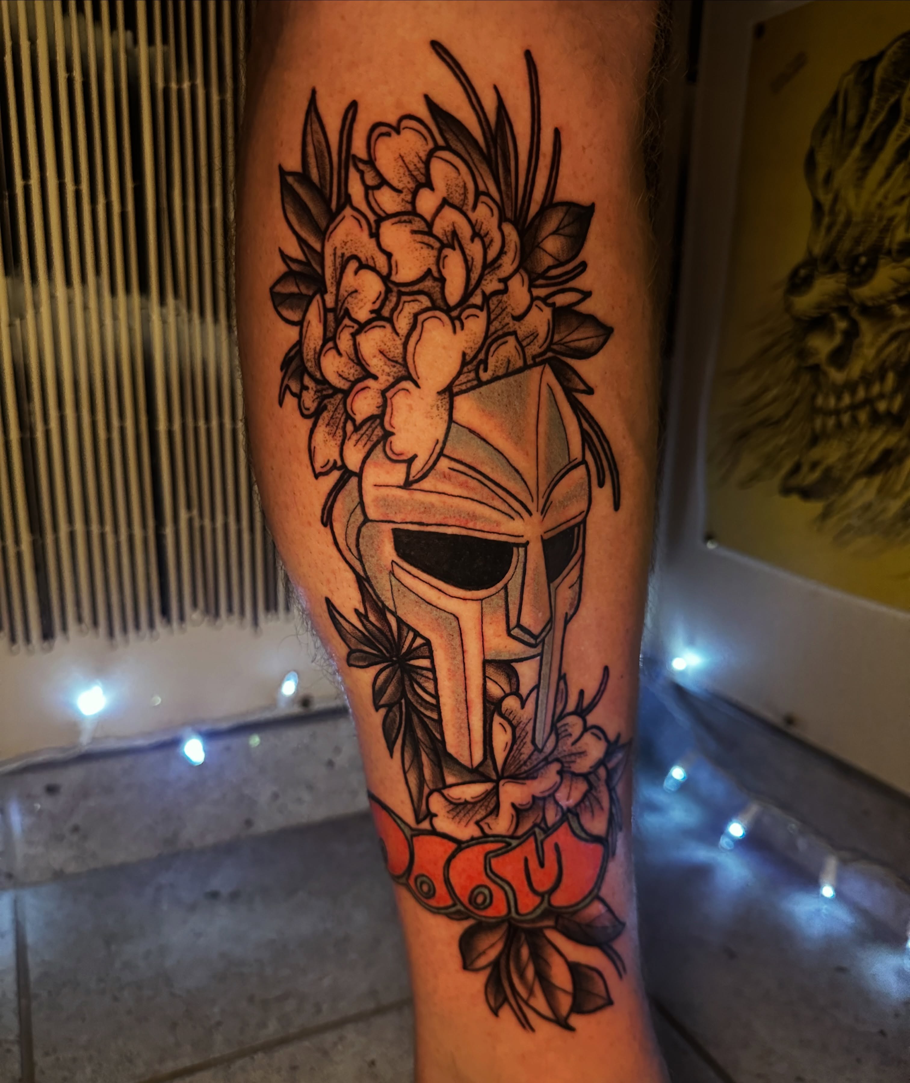 Spartan helmet with flowers neo-traditional tattoo on the forearm by Drew’s Tattoos (NH)
